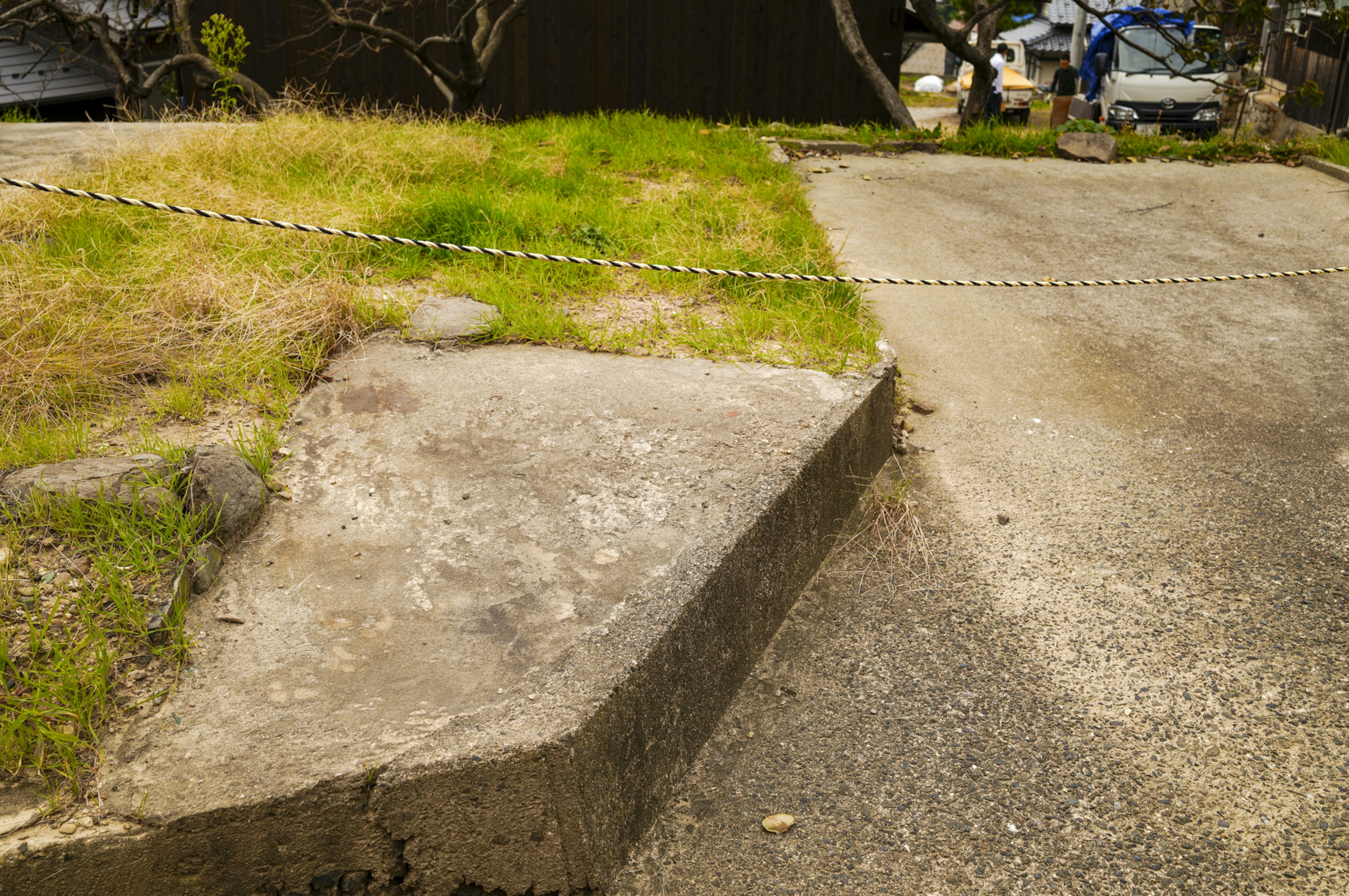 Image d'un chemin en béton incliné avec de l'herbe d'un côté