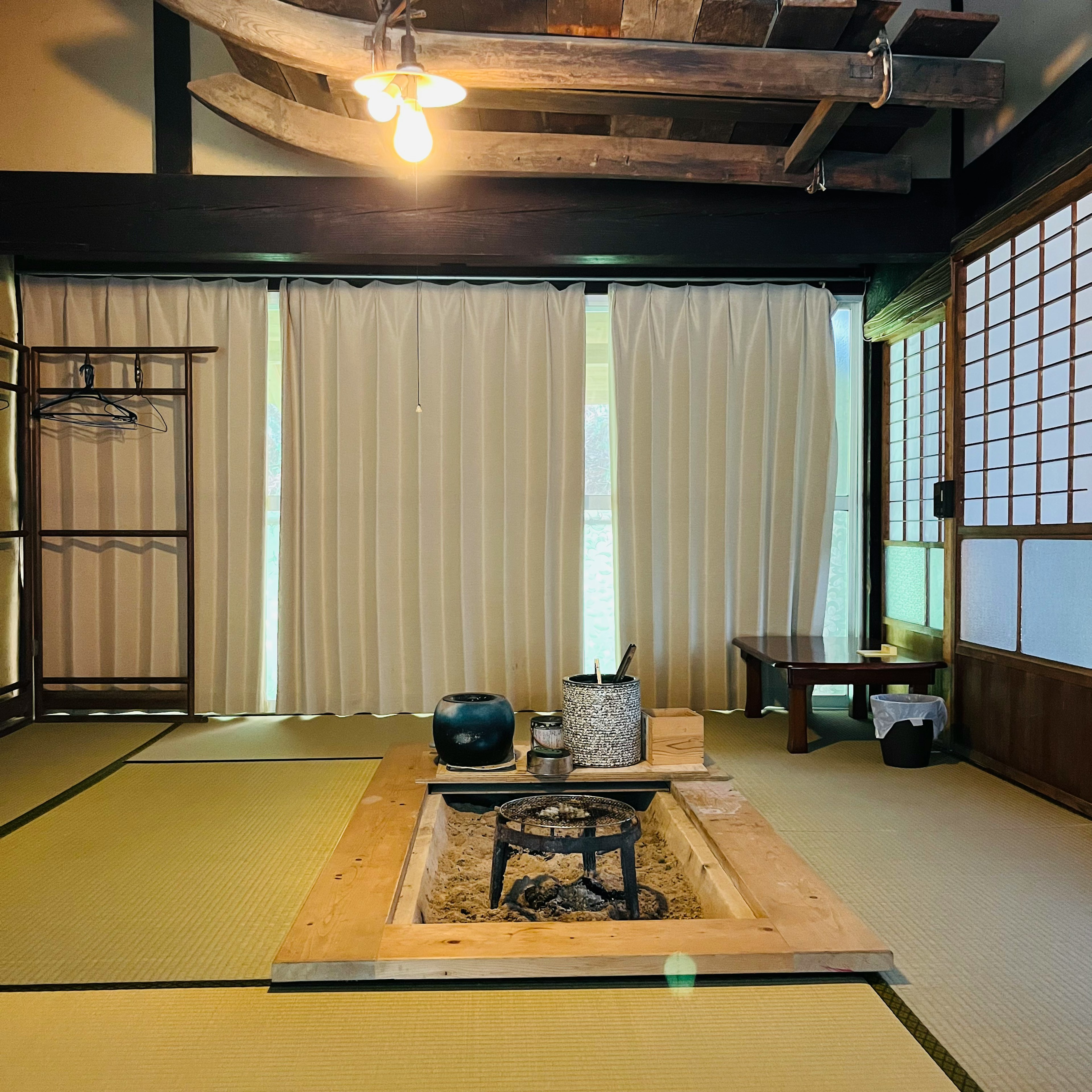 Chambre japonaise traditionnelle avec tatamis, foyer irori, poutres en bois