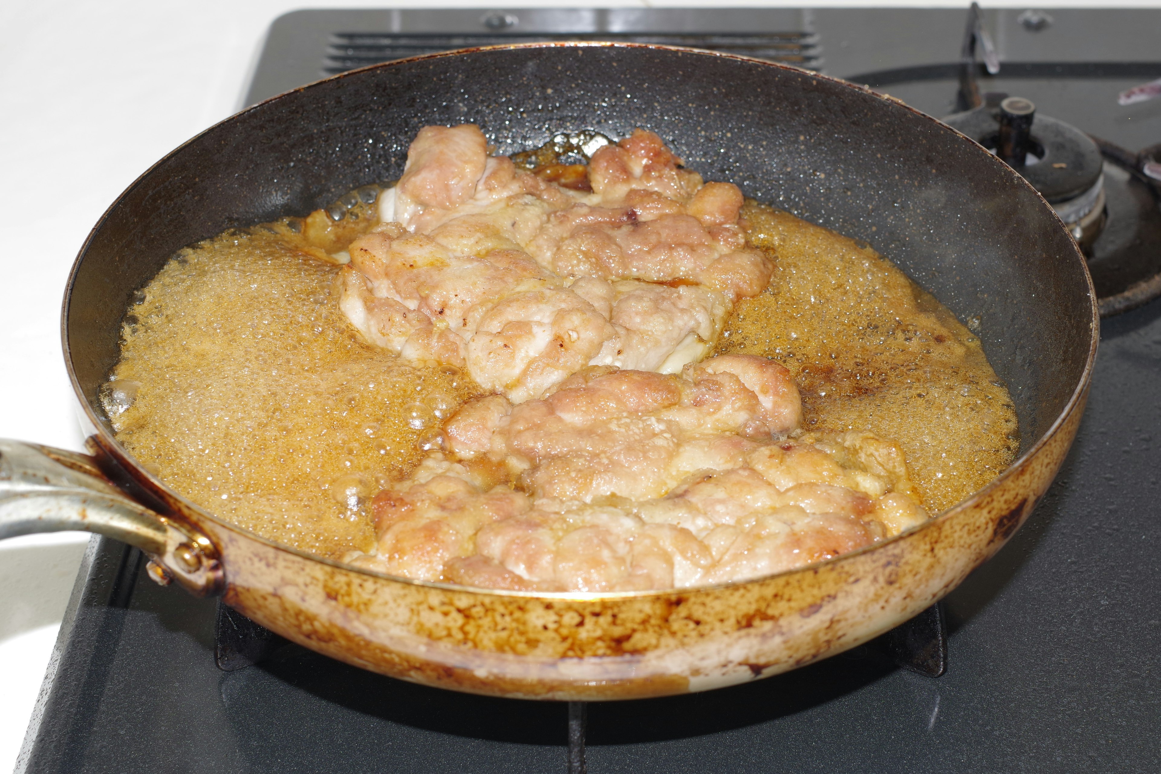 Foto von Fleischstücken, die in einer Pfanne braten