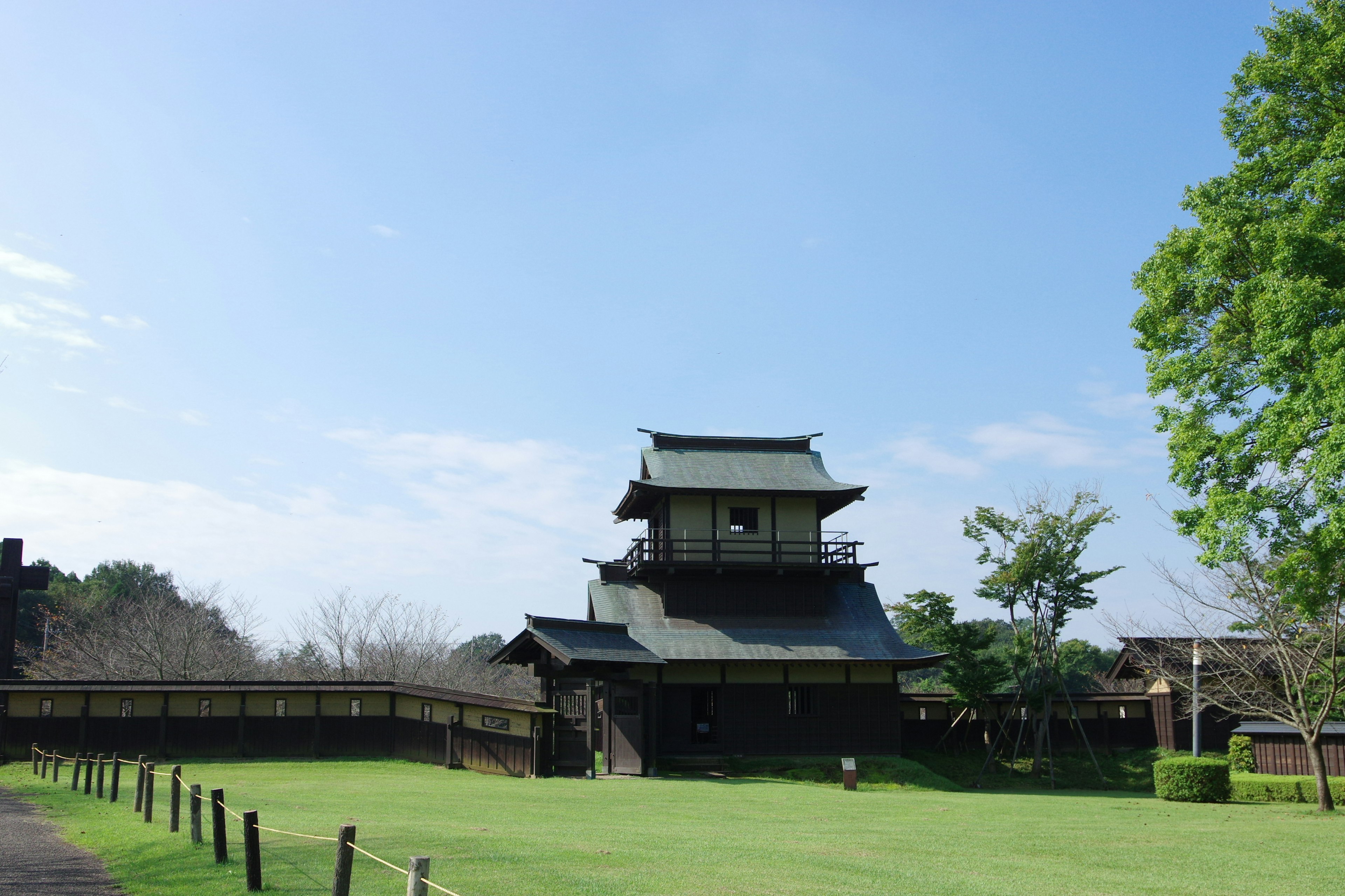 Bangunan kastil tradisional Jepang di taman hijau