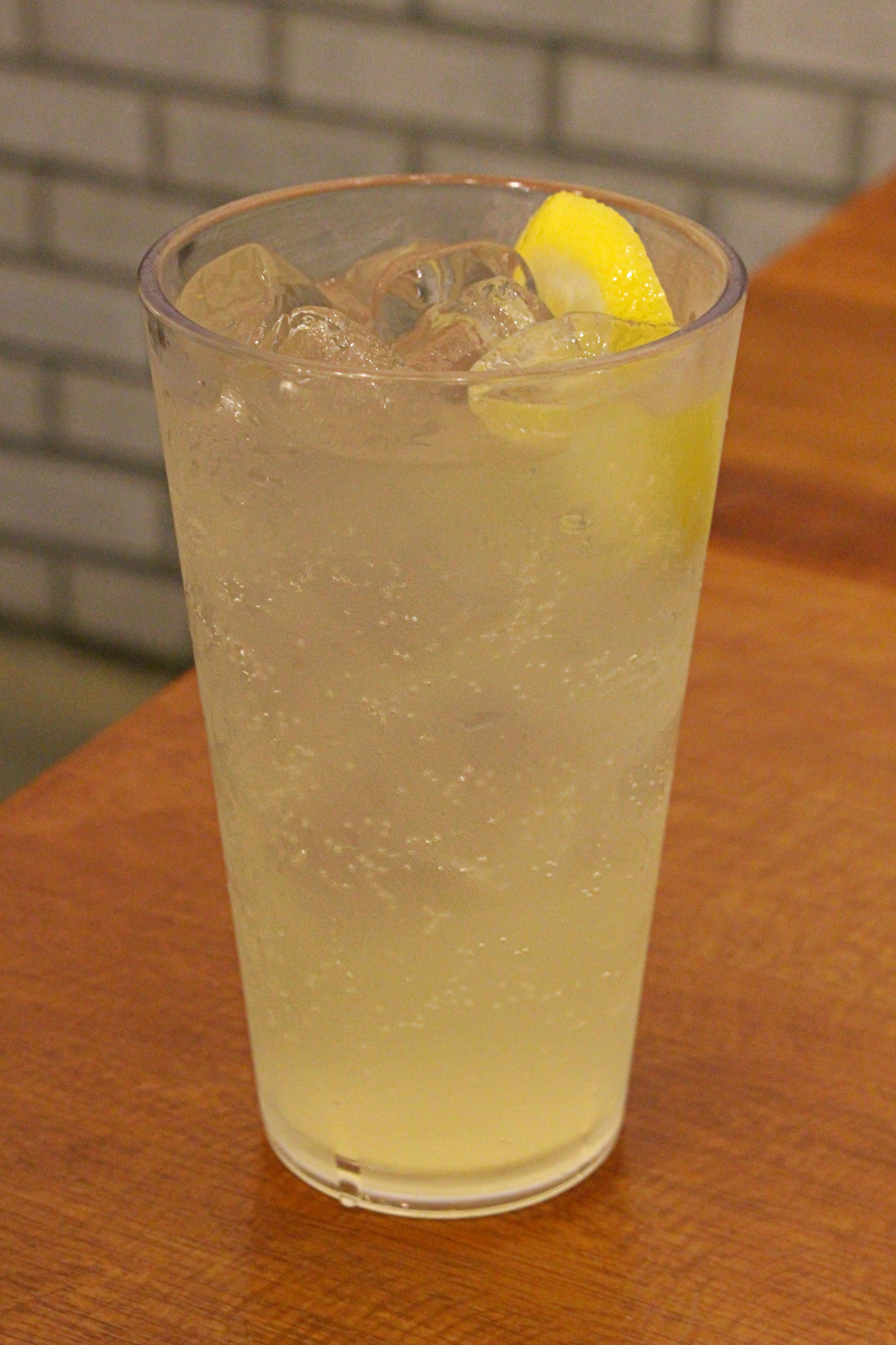 Glas Limonade mit Eis und einer Scheibe Zitrone