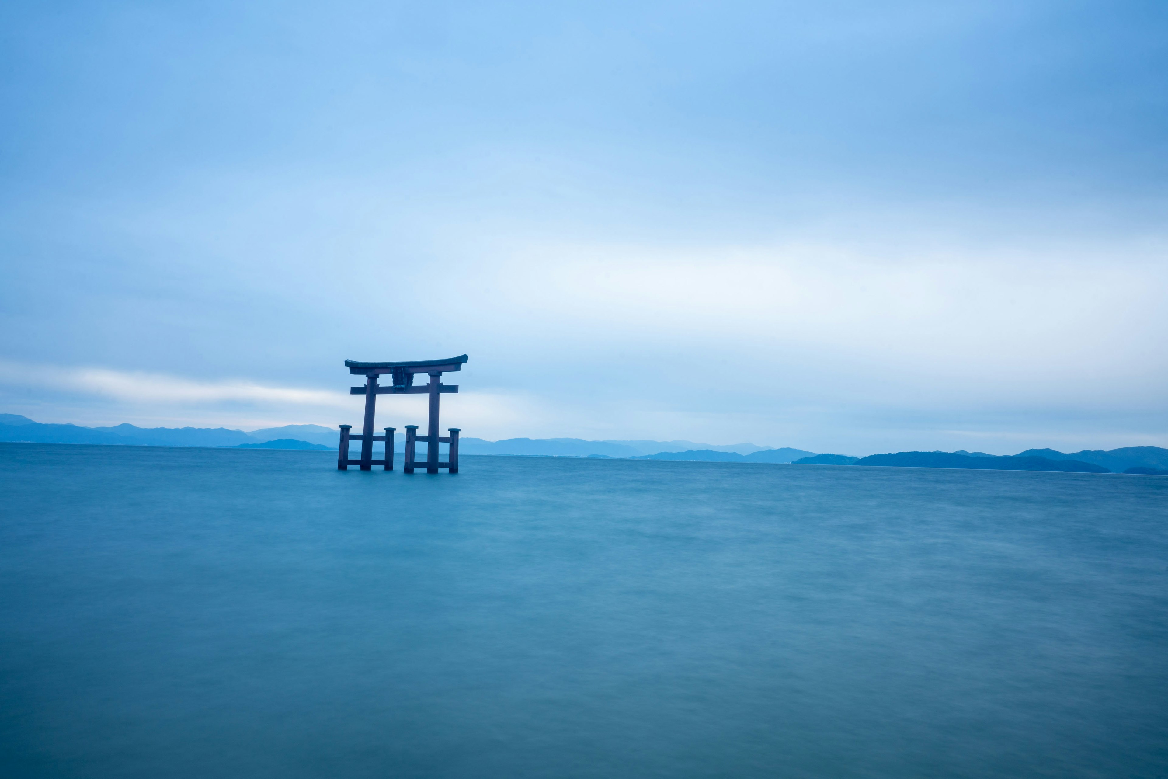 Siluet torii mengapung di air biru