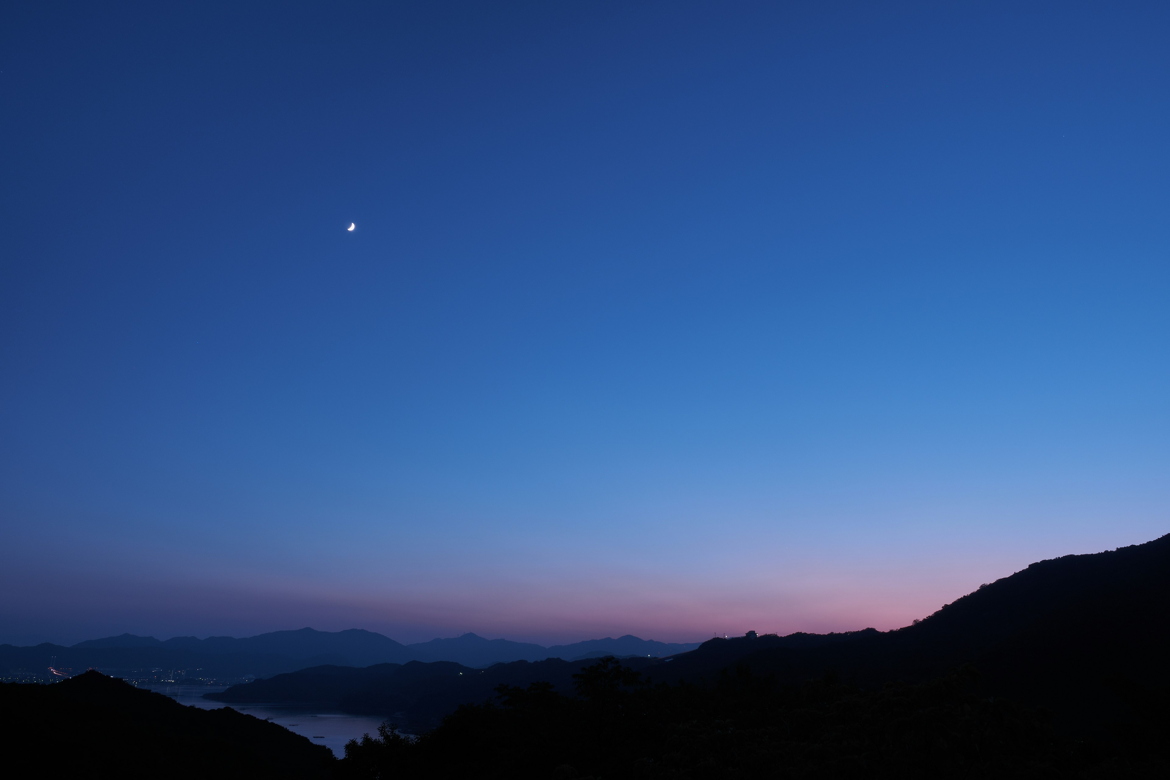 깊은 파란 밤하늘과 먼 산, 밝은 별이 있는 경치