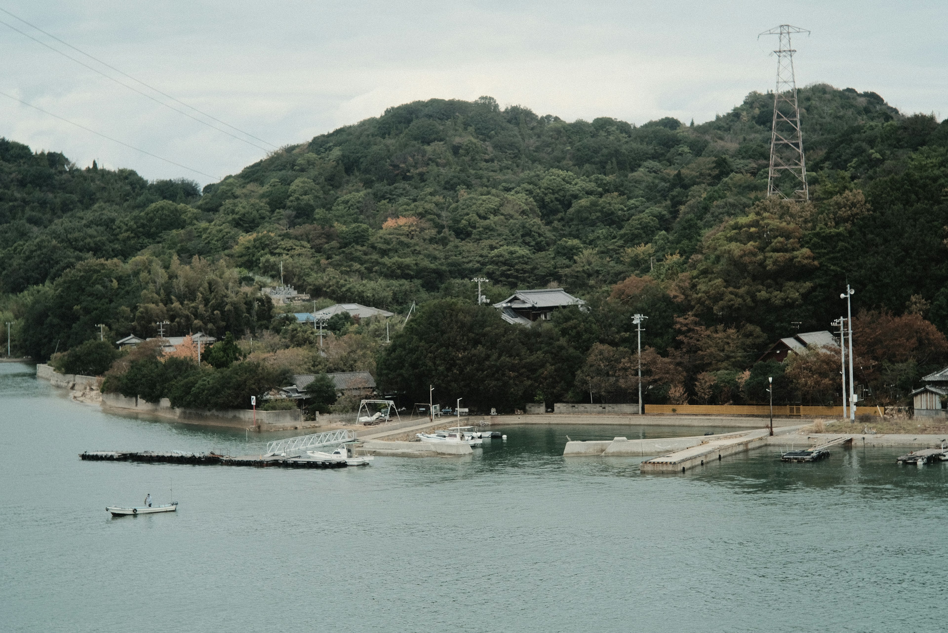 Scenic view of a calm waterway with small boats and lush green hills