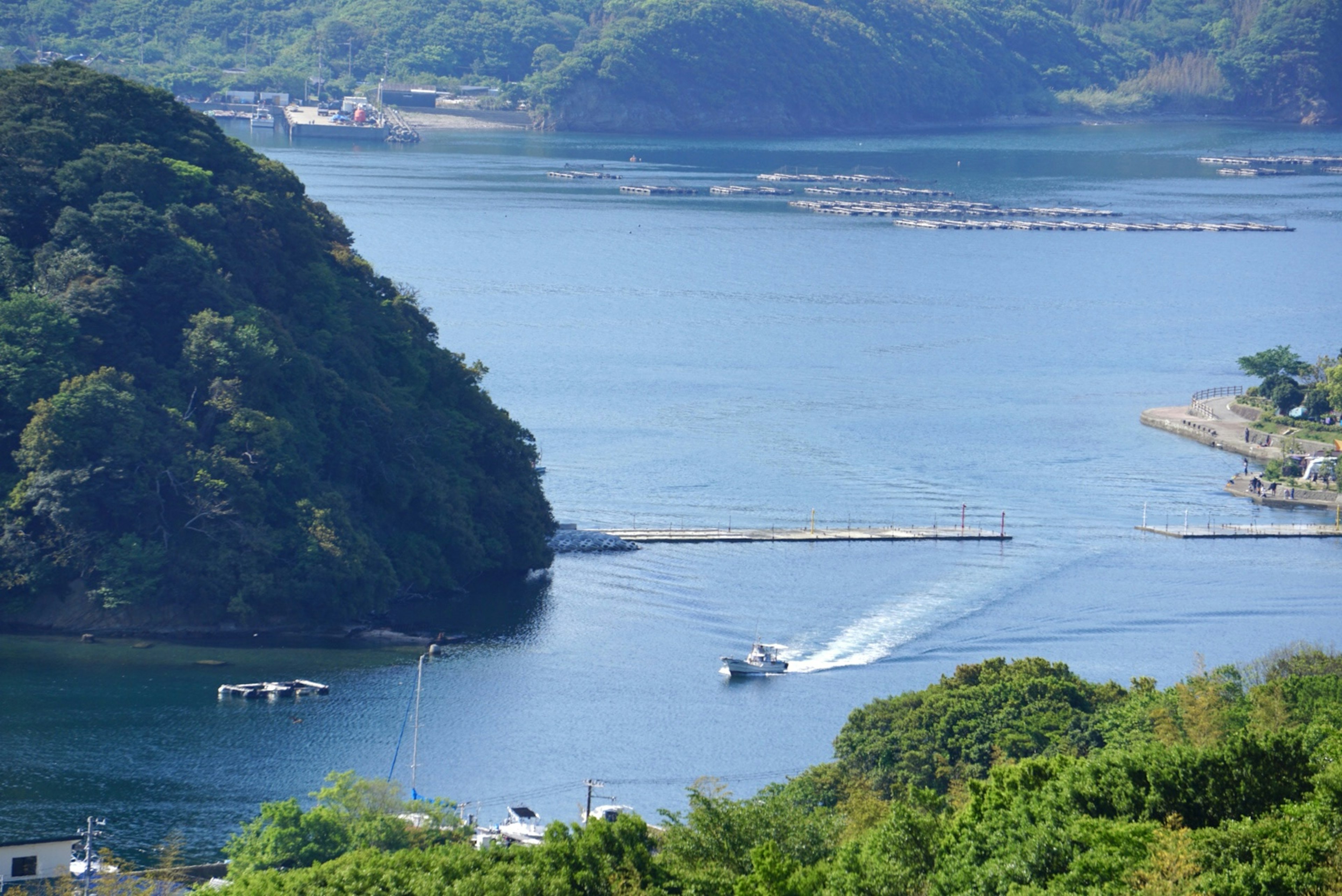 青い水面に小舟が走る美しい風景