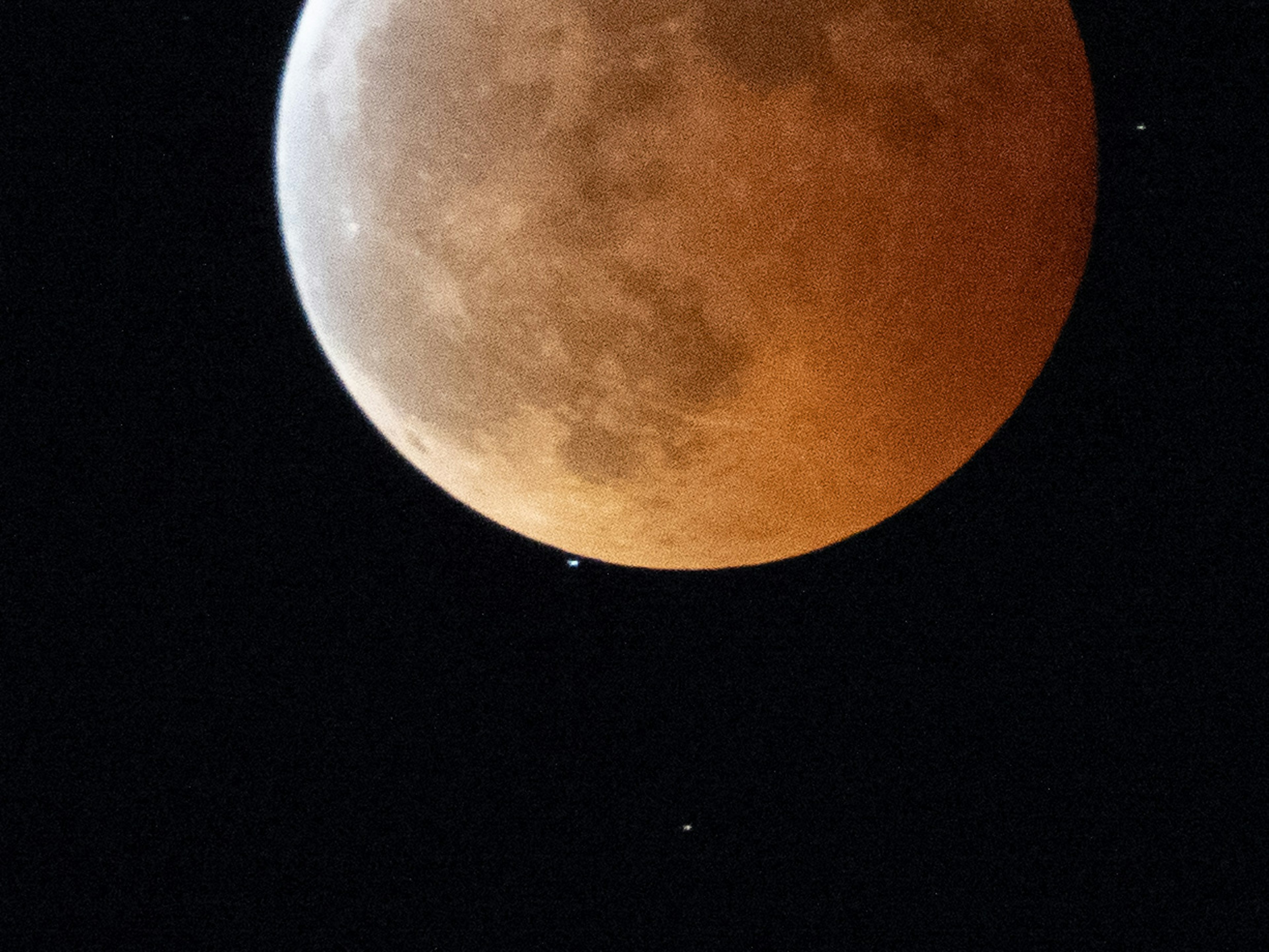 Une belle vue d'une lune rouge et des étoiles dans le ciel nocturne