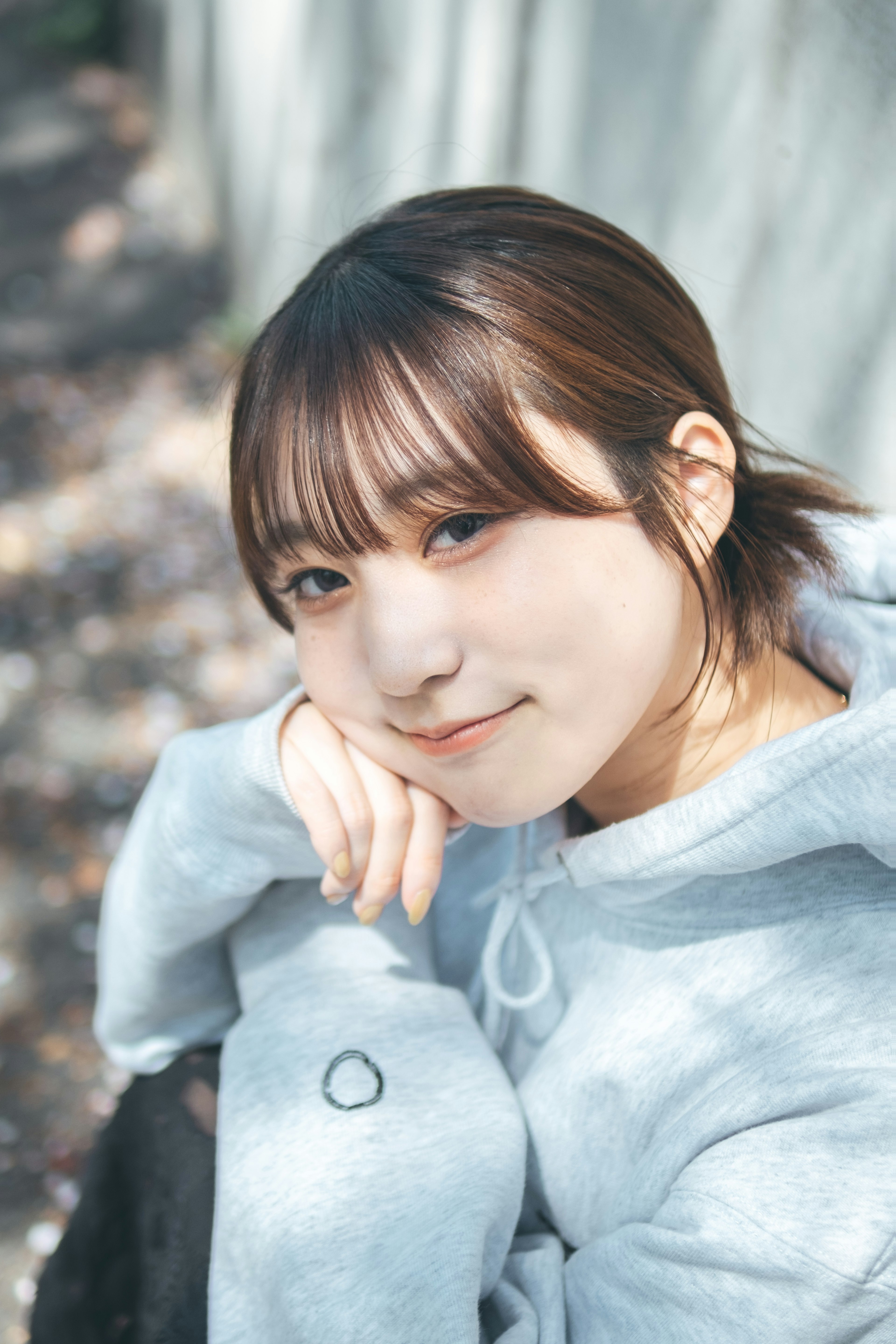 Joven mujer sonriendo con sudadera gris