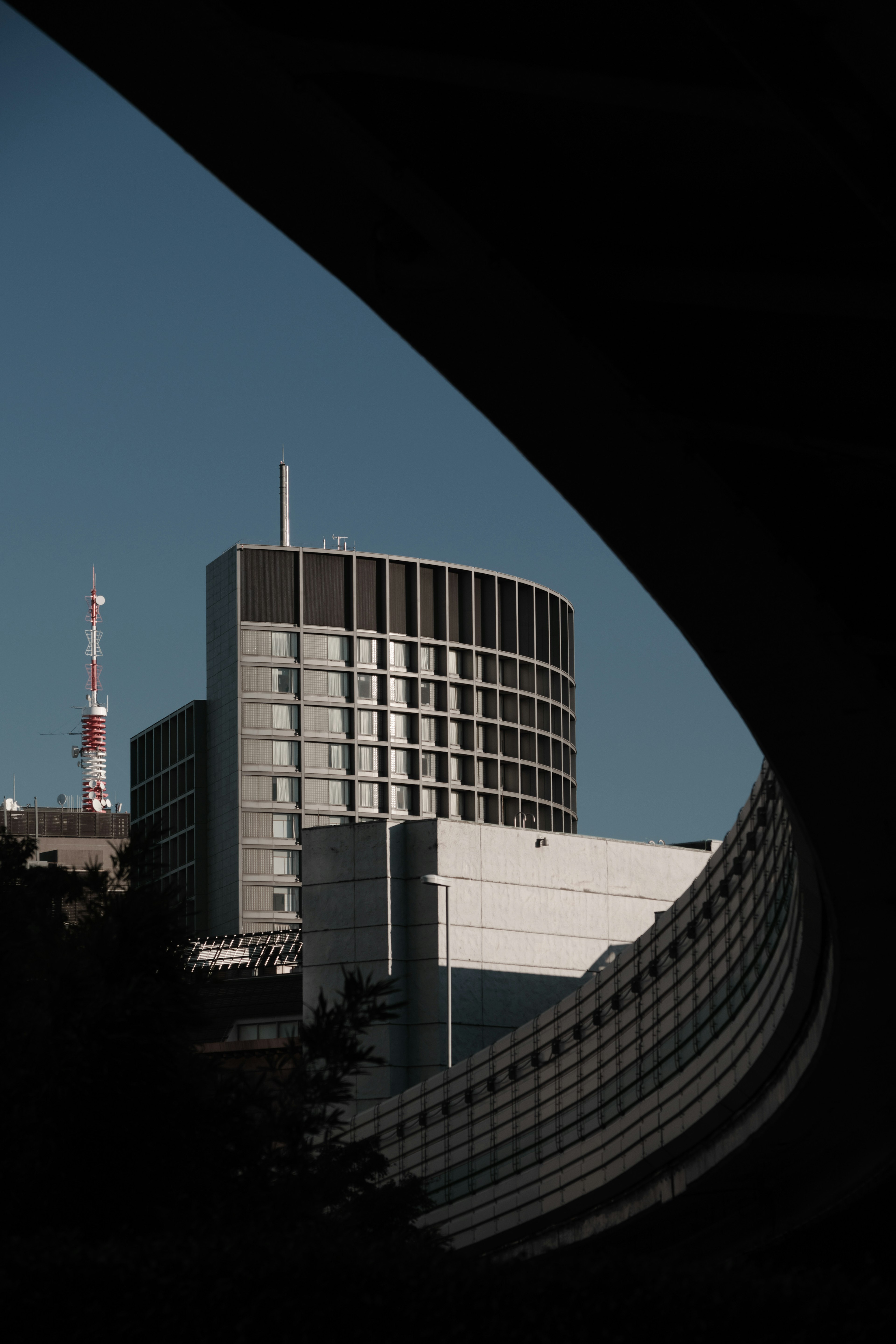 Modernes Gebäude mit gebogenem Vordergrund und hoher Antenne