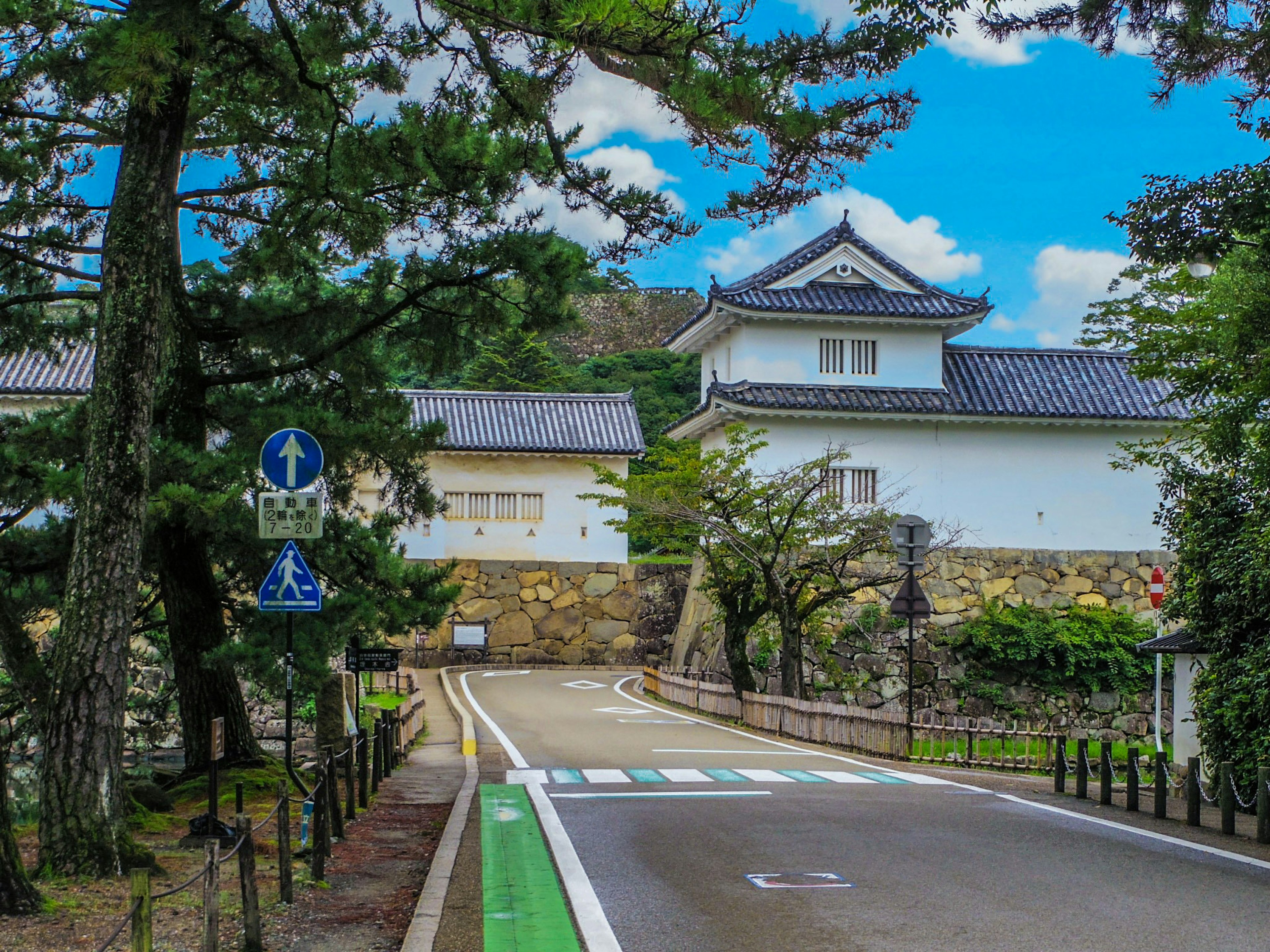 城と緑の木々が見える静かな道