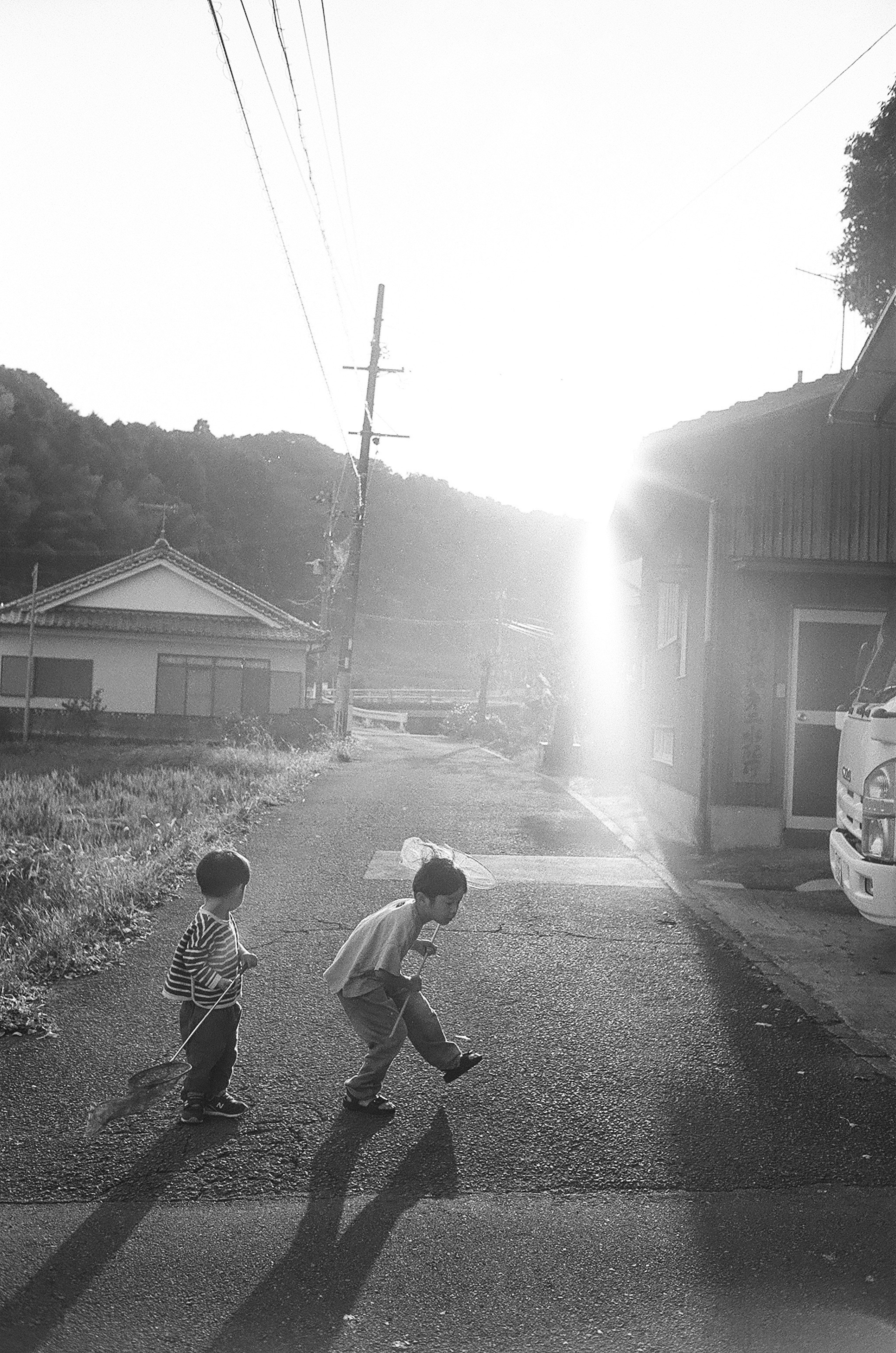 Enfants courant vers le coucher de soleil sur une rue tranquille