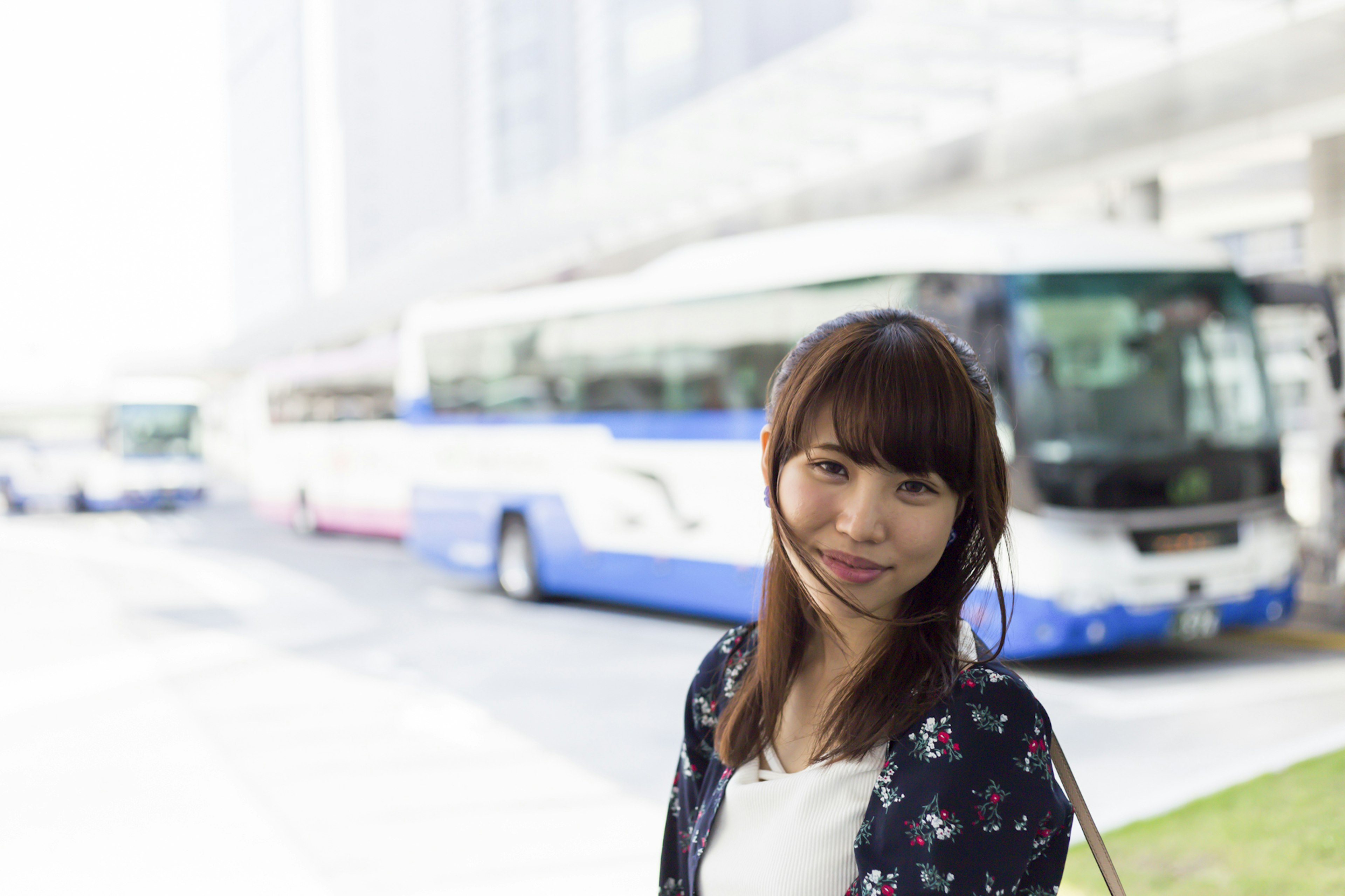 Femme souriante se tenant devant des bus