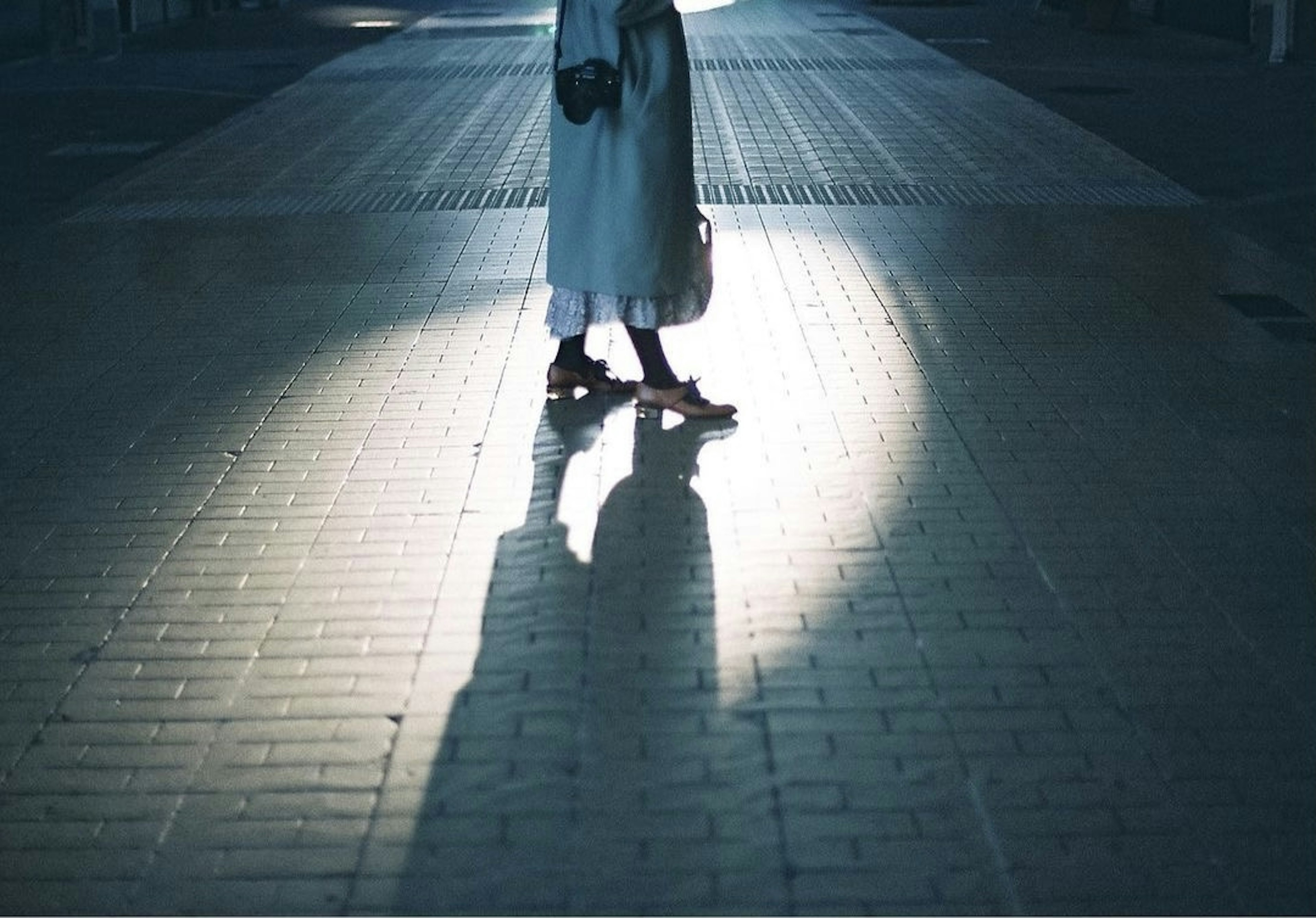 Image capturant l'ombre d'une personne debout dans une lumière bleutée