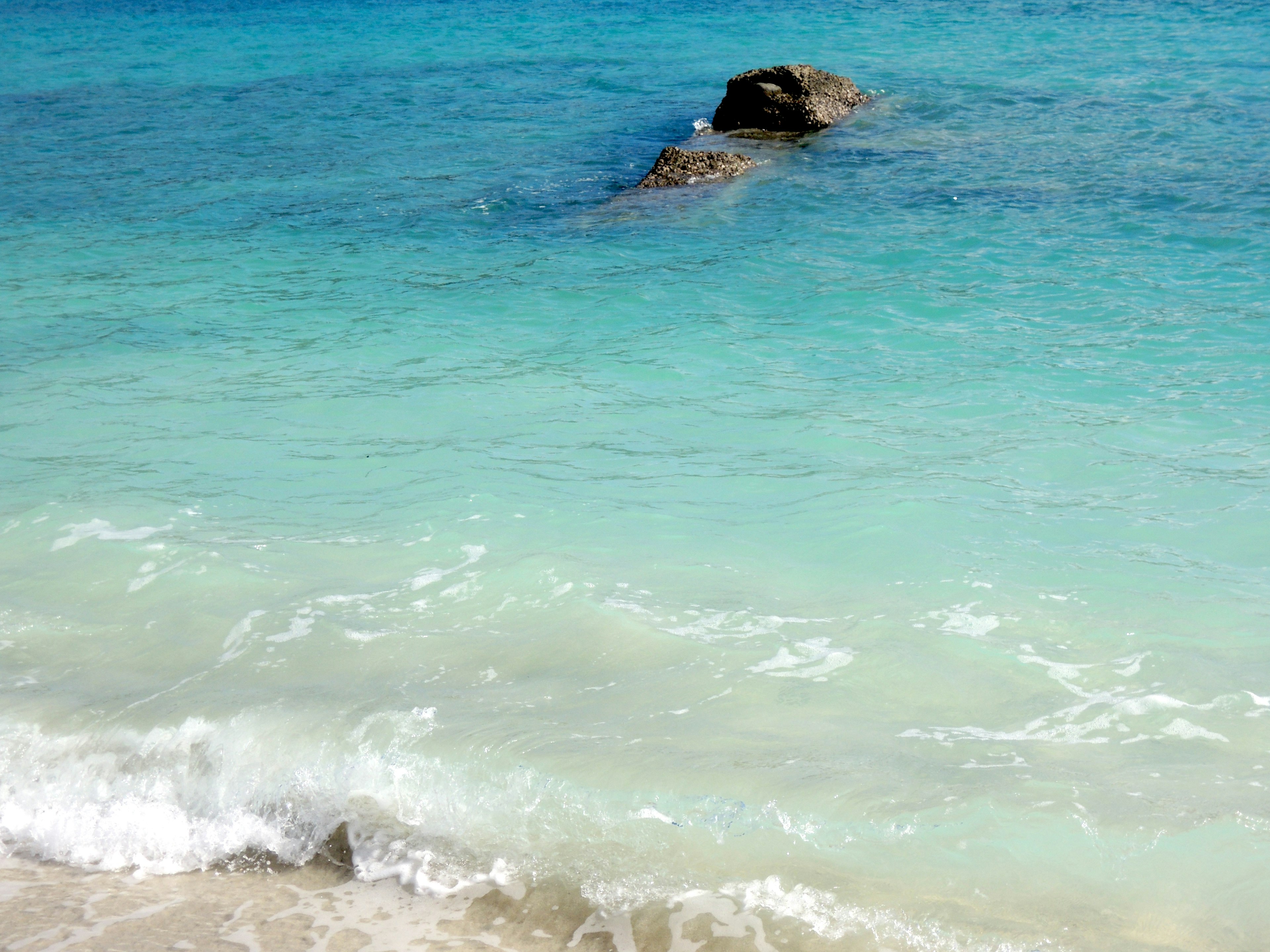 Hermosa escena de playa con agua azul y olas blancas