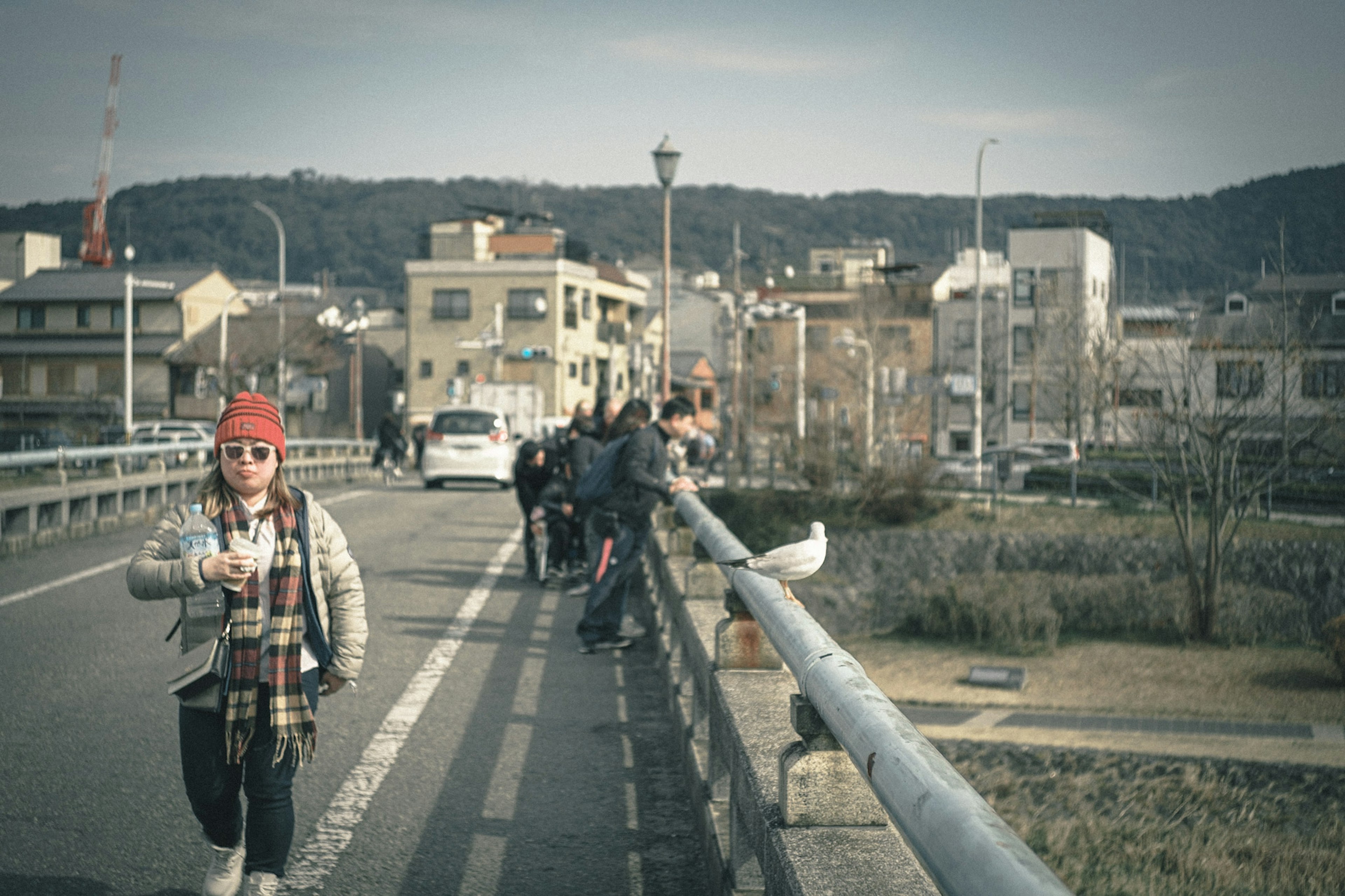 橋の上を歩く女性と背景の街並み