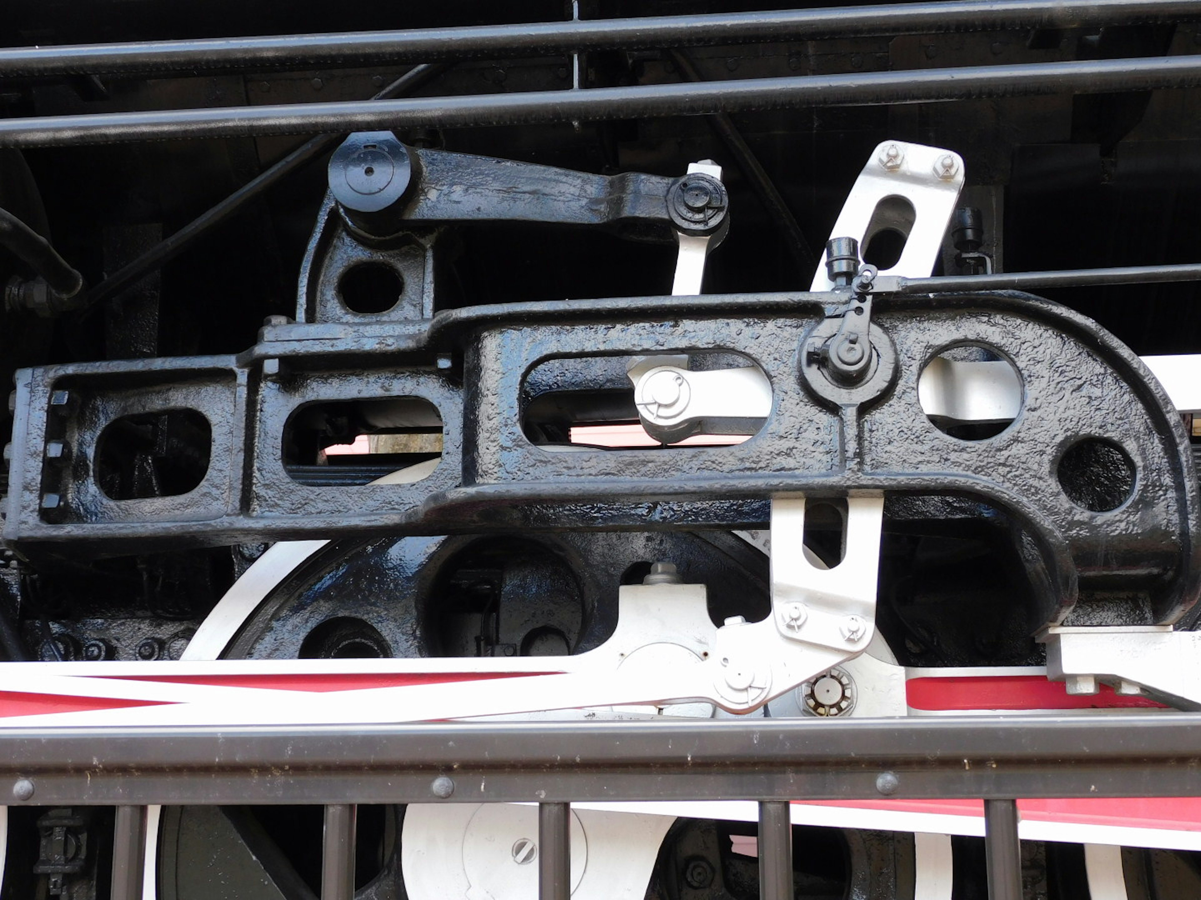 Detailed image of a black mechanical component part of a train showing mechanical structure and motion