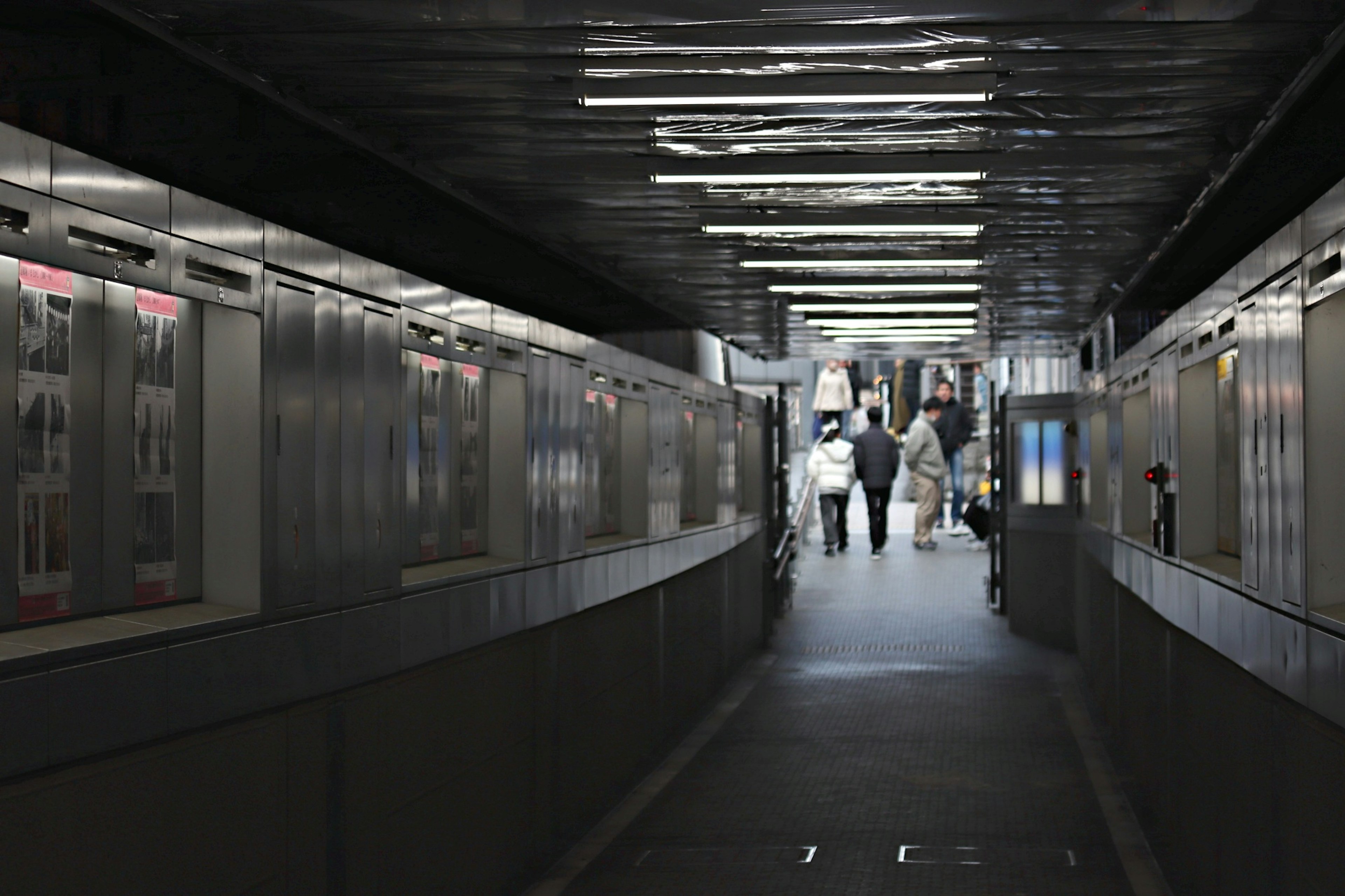 Dimly lit corridor with people walking