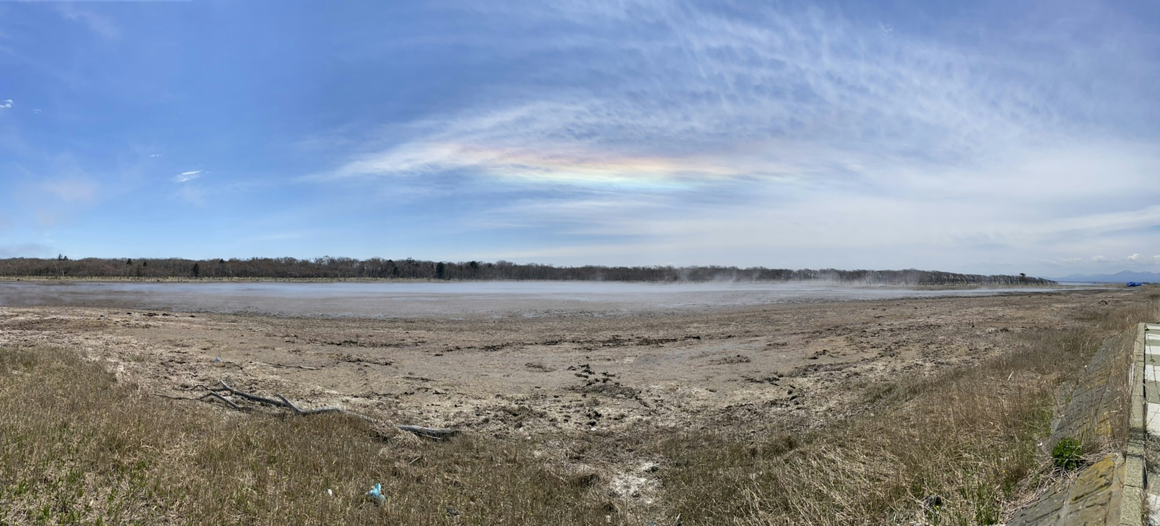 Panoramablick auf eine weite Ebene mit blauem Himmel und nebligem Boden