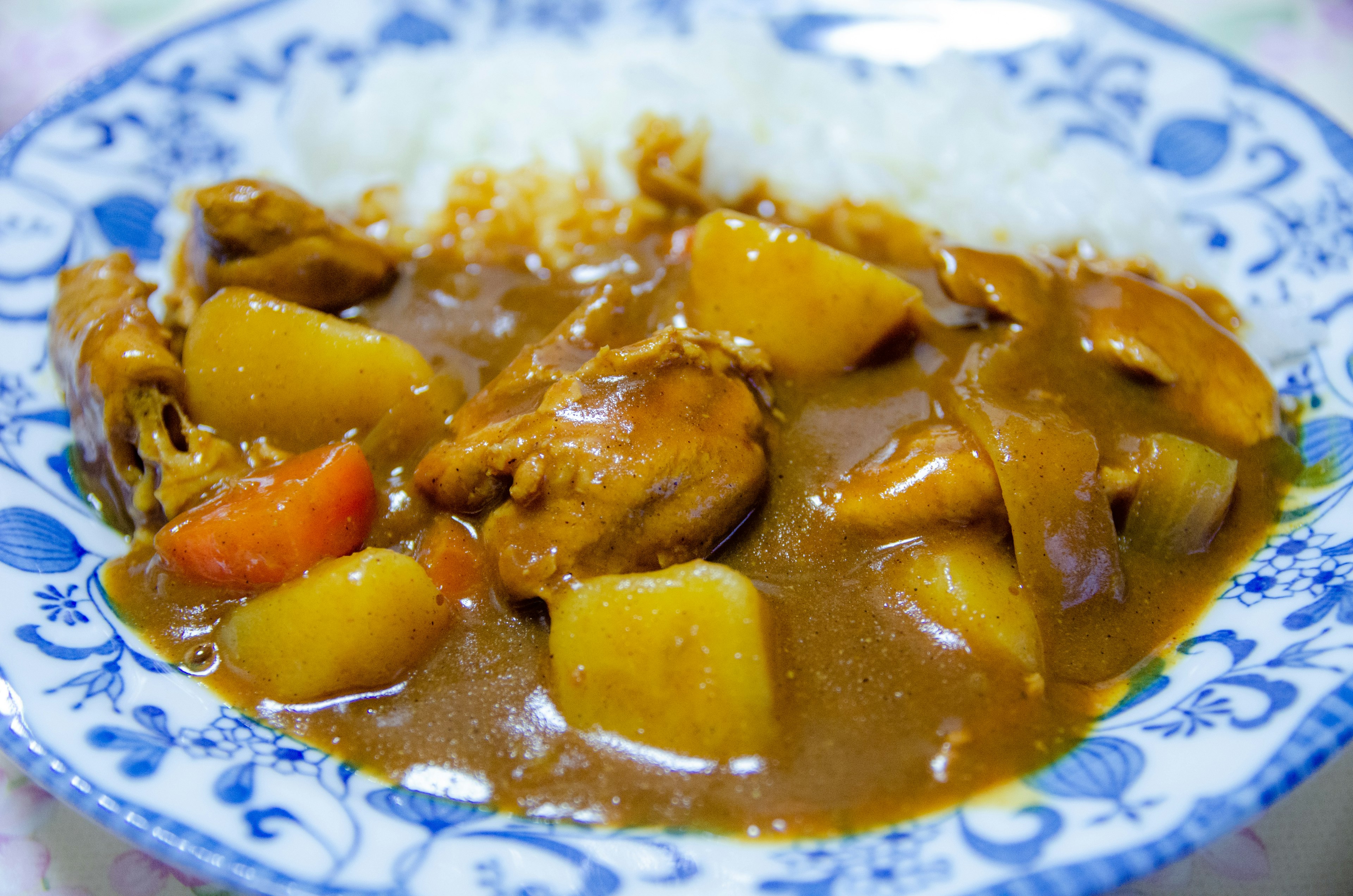 Plato de curry con pollo y verduras junto a arroz blanco