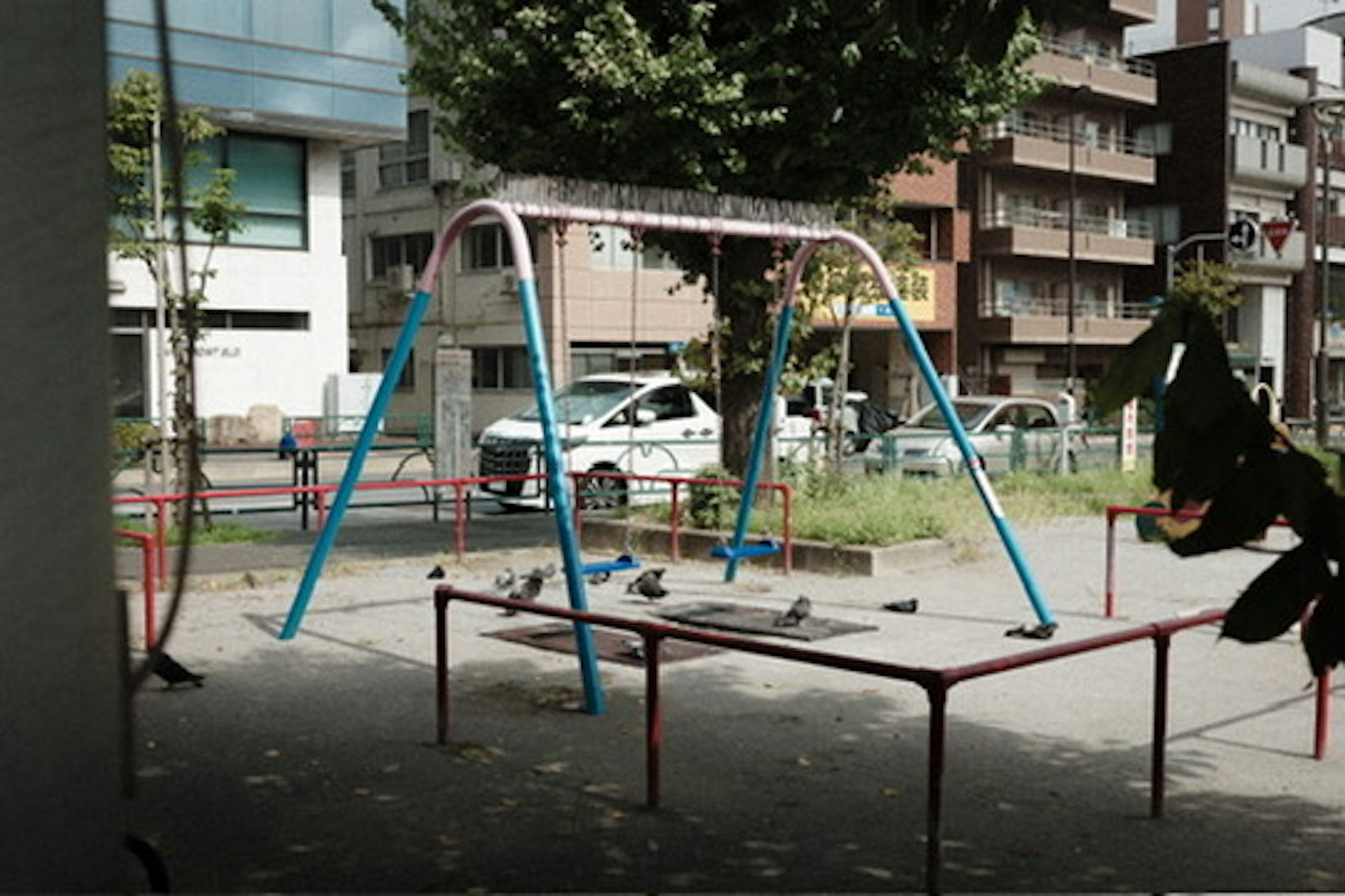 公園のブランコと周囲の建物の風景