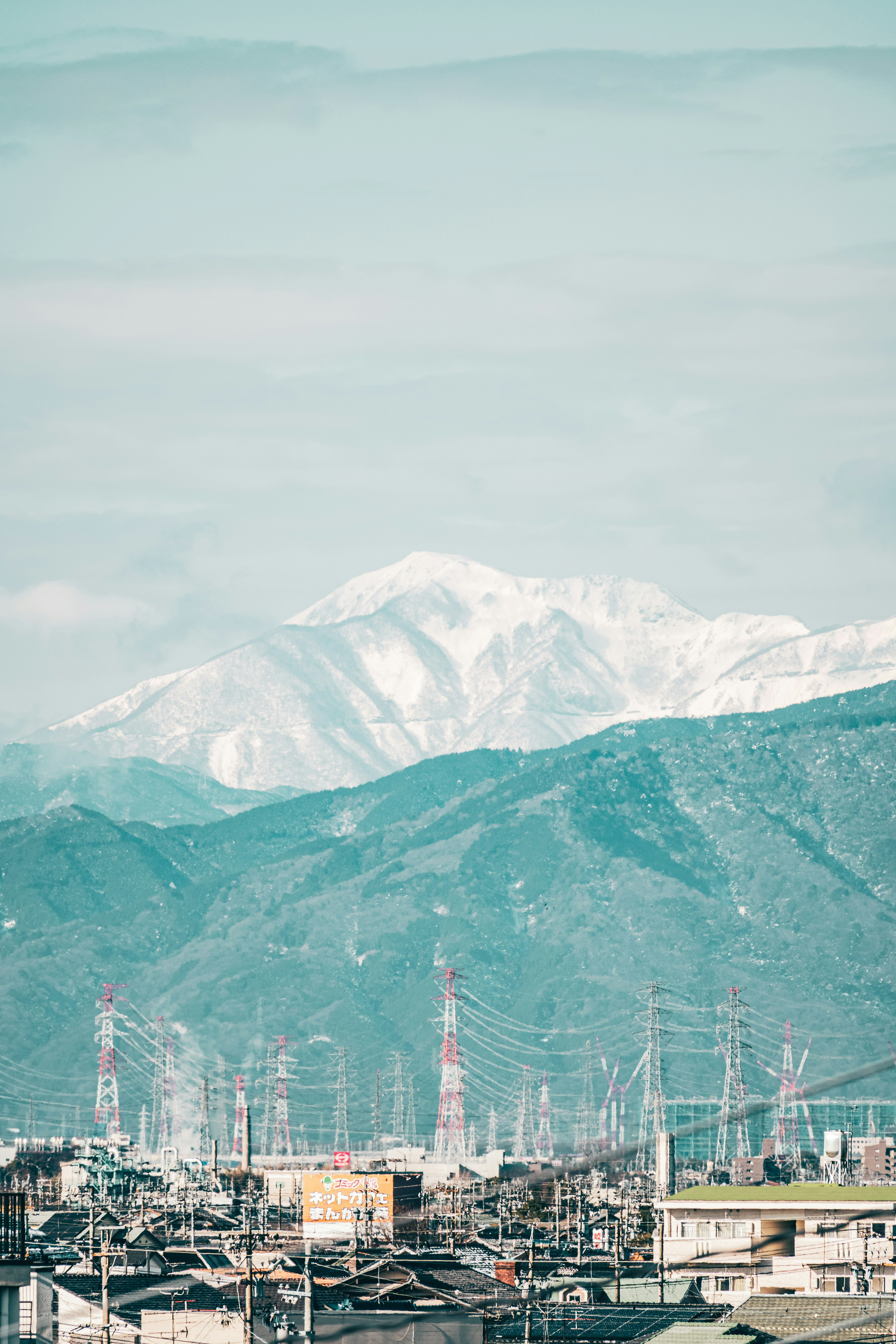 雪をかぶった山々と都市の風景が見える