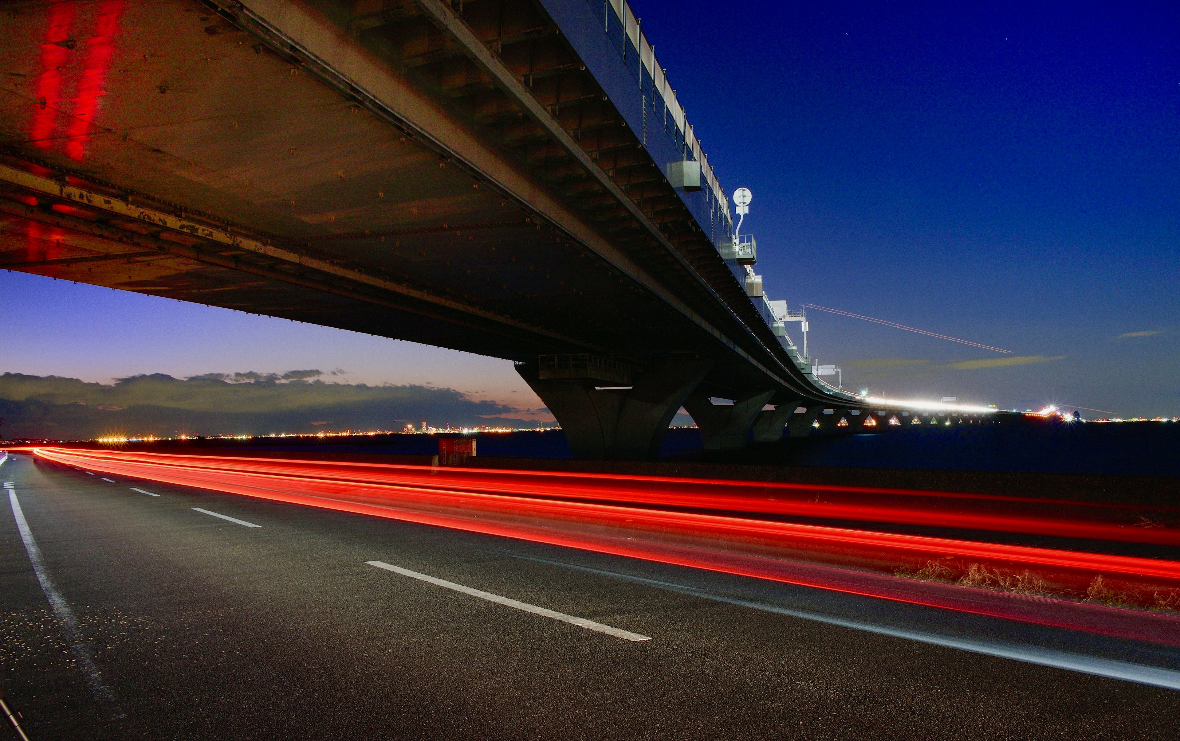 Un pont sous le ciel nocturne avec des lumières de voiture en mouvement