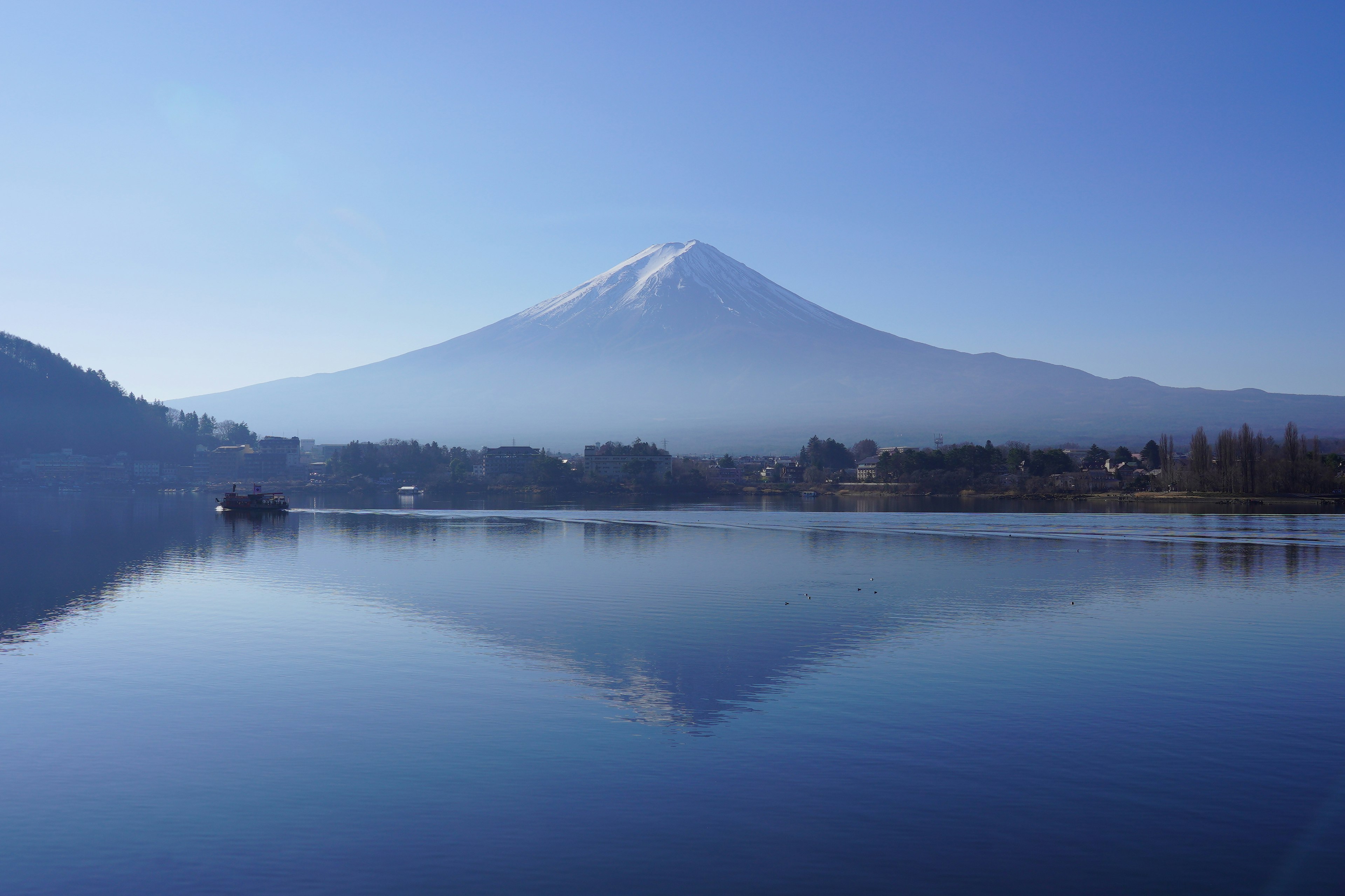 Der Fuji-Berg spiegelt sich in einem ruhigen See unter einem klaren blauen Himmel