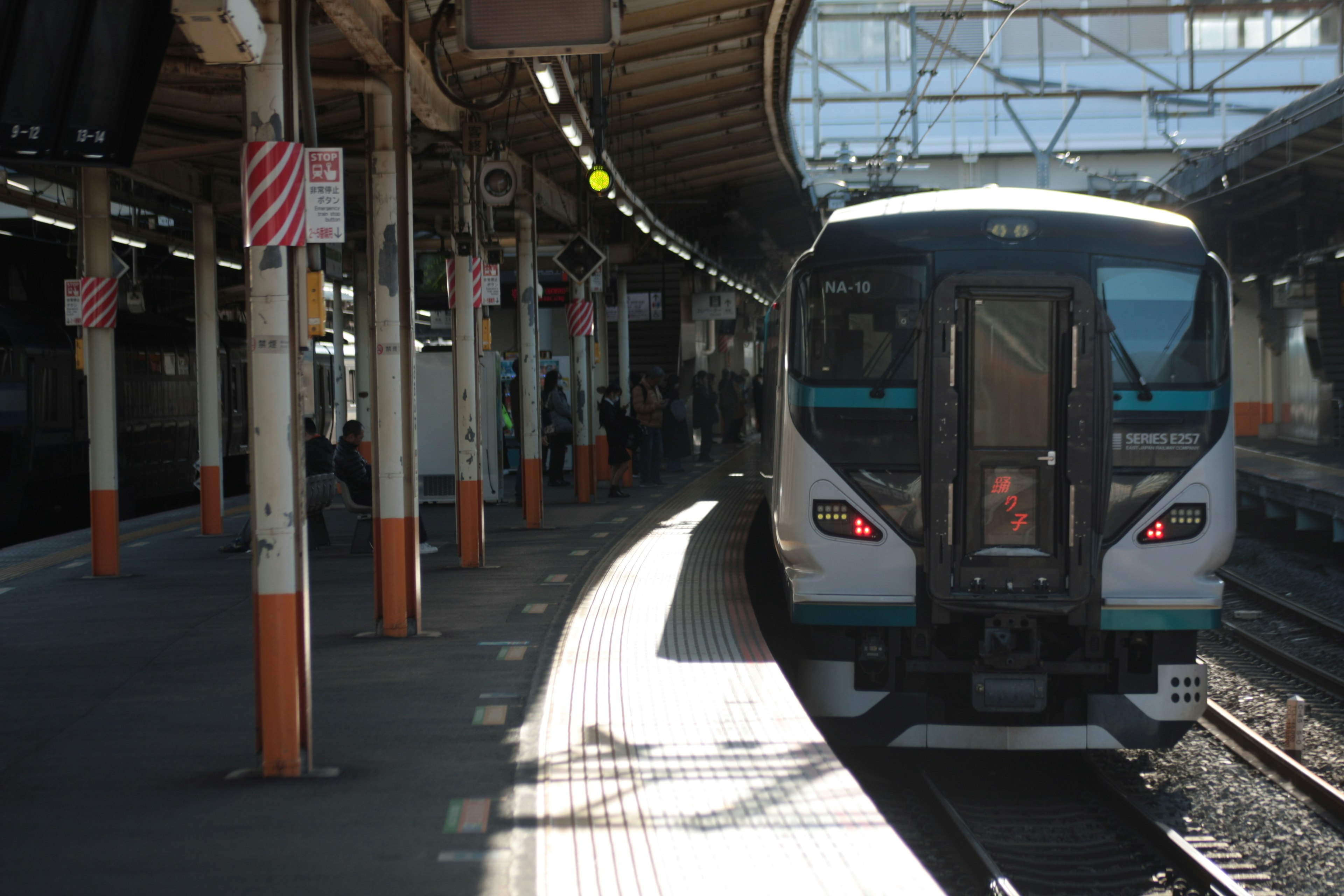 Train at a station with passengers waiting