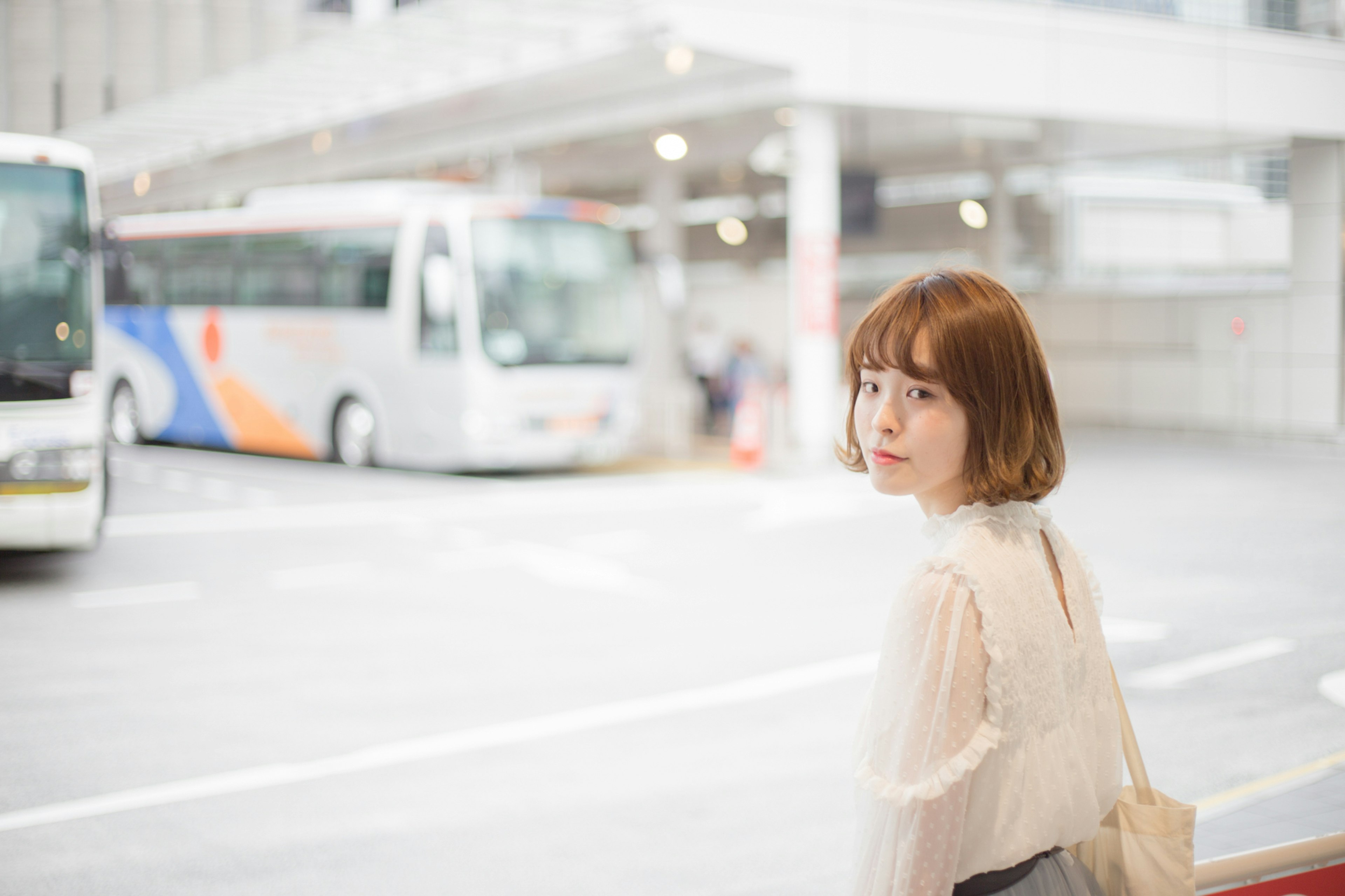 Portrait of a woman looking back at a bus stop