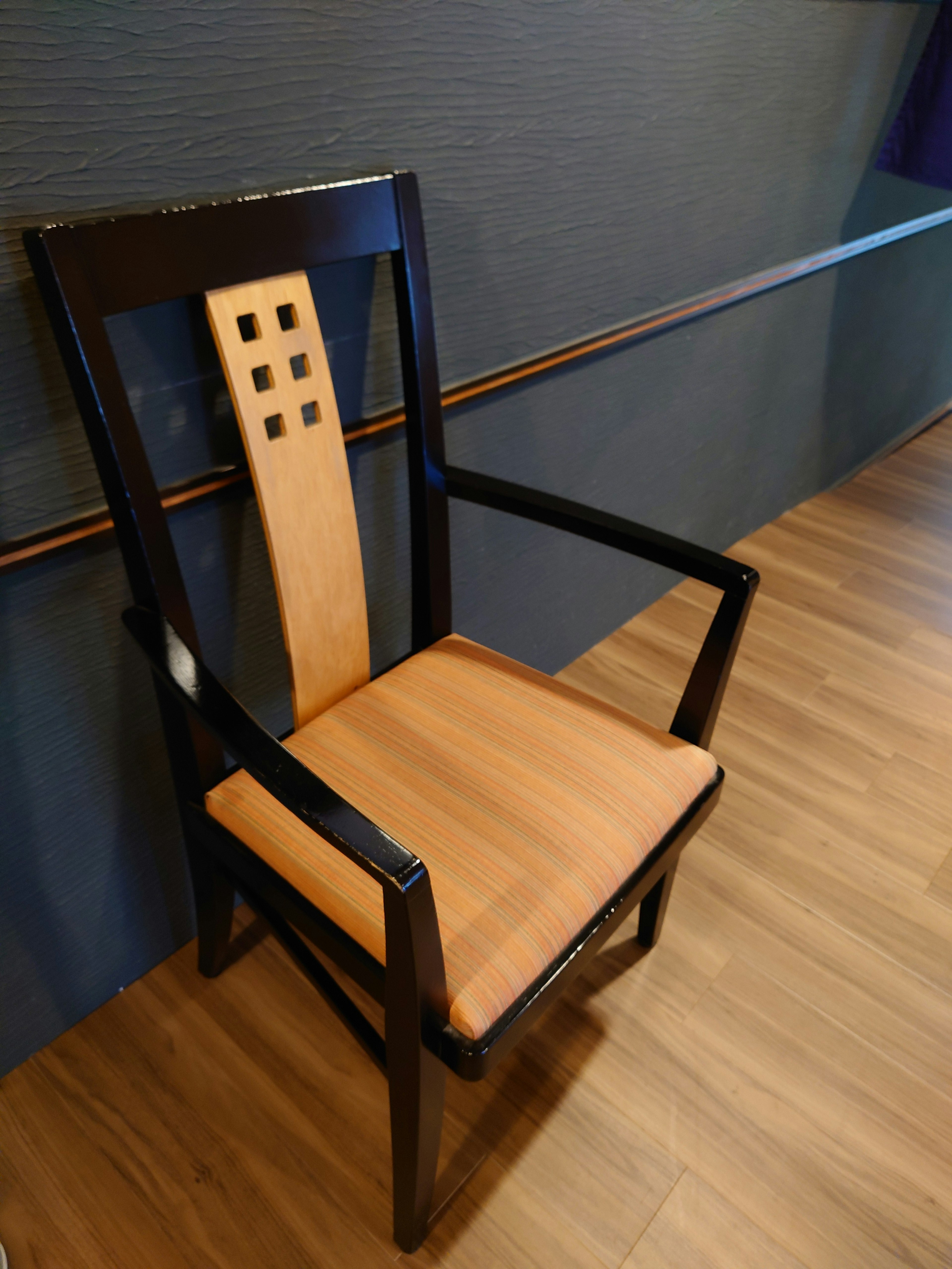 Silla de madera negra con asiento de roble y respaldo con cuatro agujeros