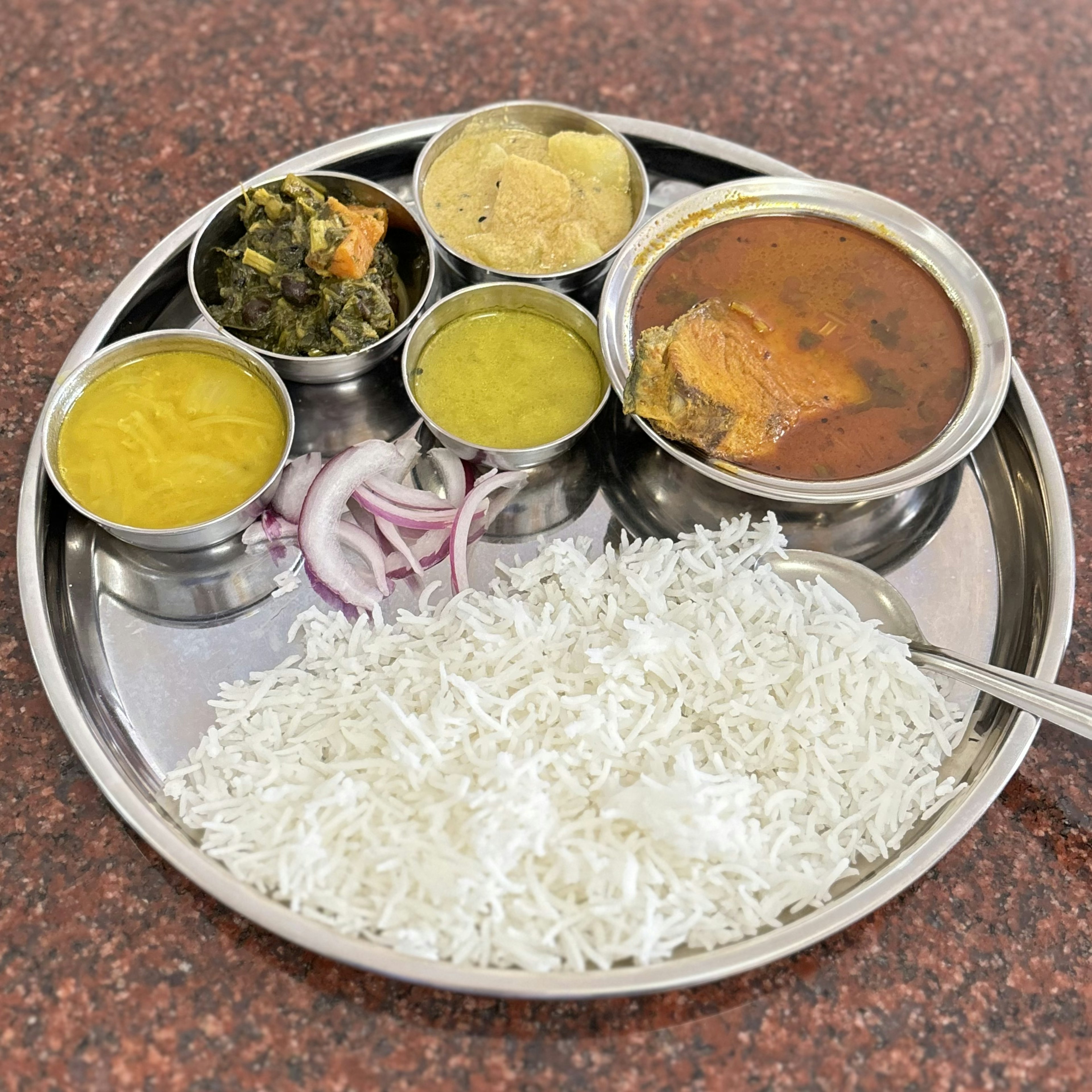 Plate of South Indian cuisine with white rice and various curries and side dishes