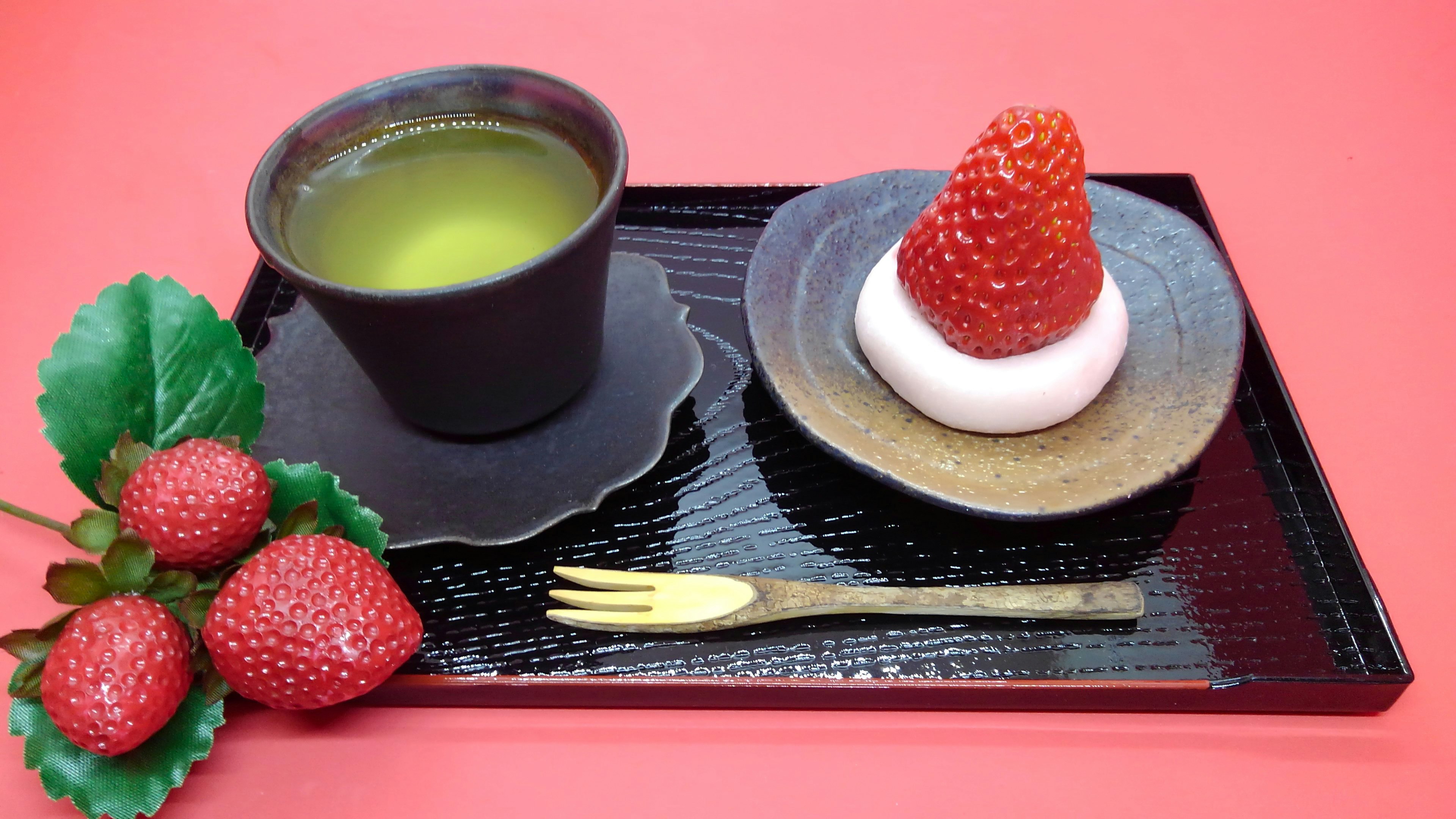 Traditional Japanese tray featuring green tea and a strawberry dessert