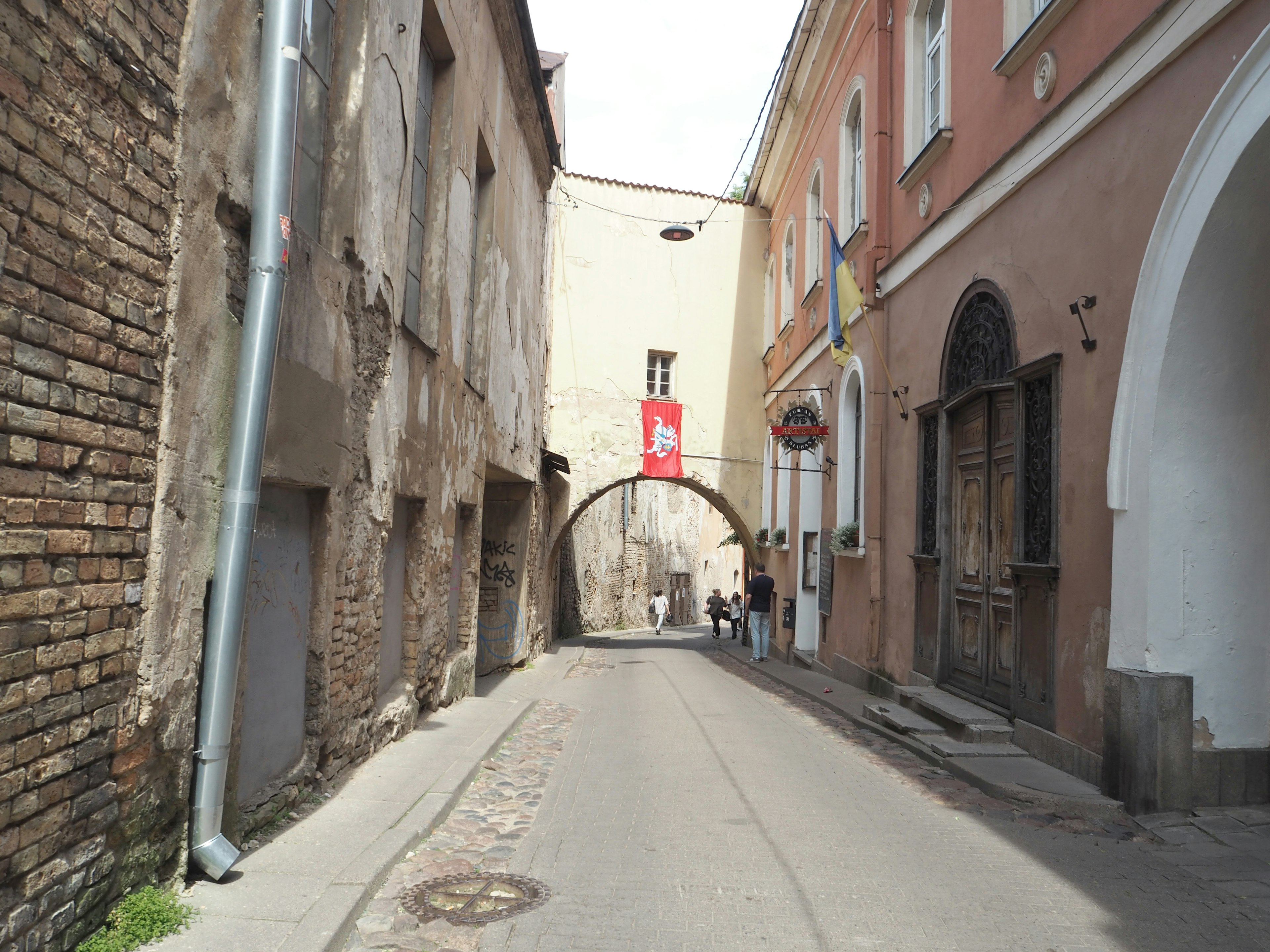 Rue étroite avec des bâtiments anciens et une arche en arrière-plan