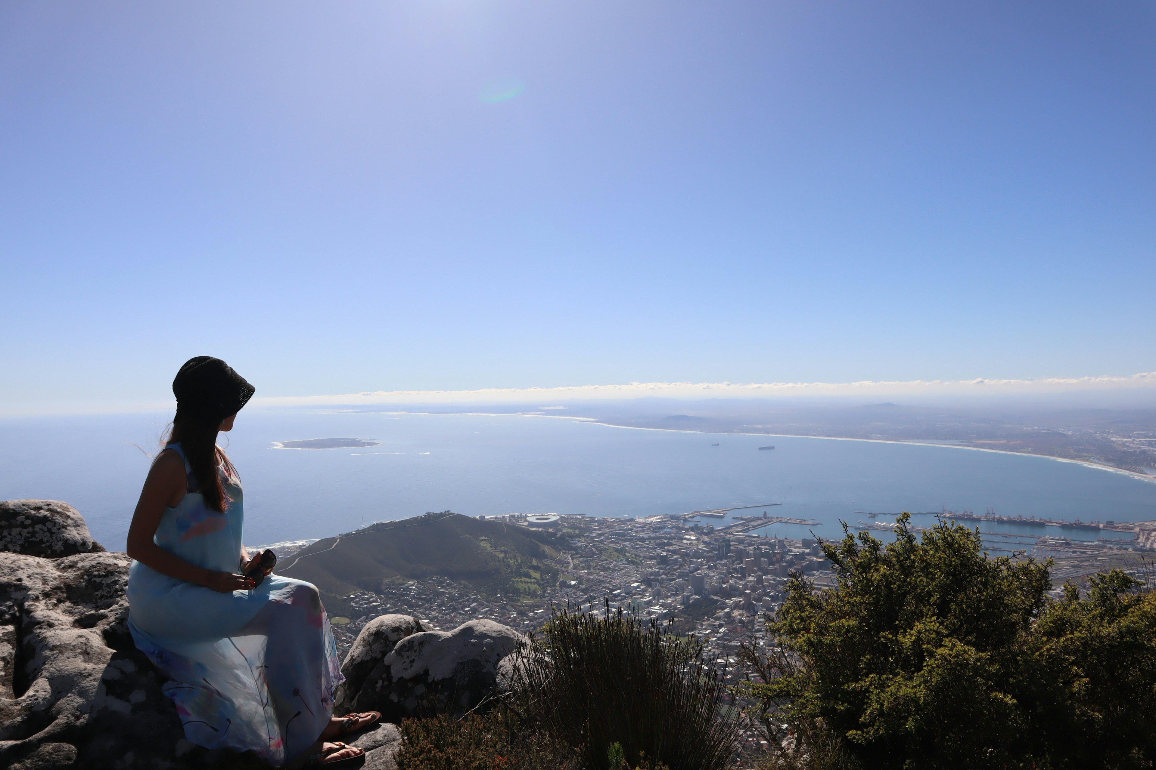 Silhouette of a woman overlooking the sea and city