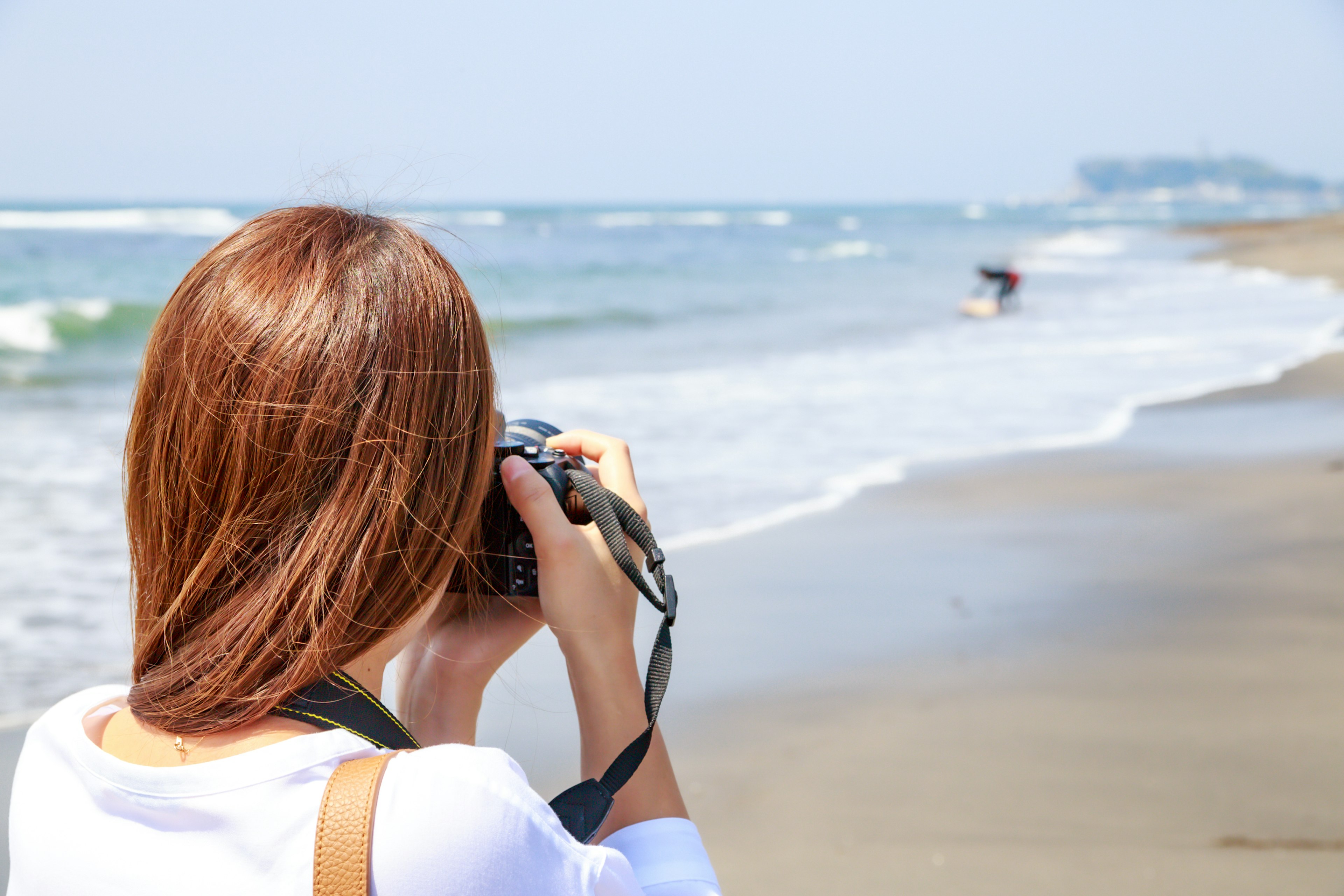 Una donna che scatta foto in spiaggia con una macchina fotografica