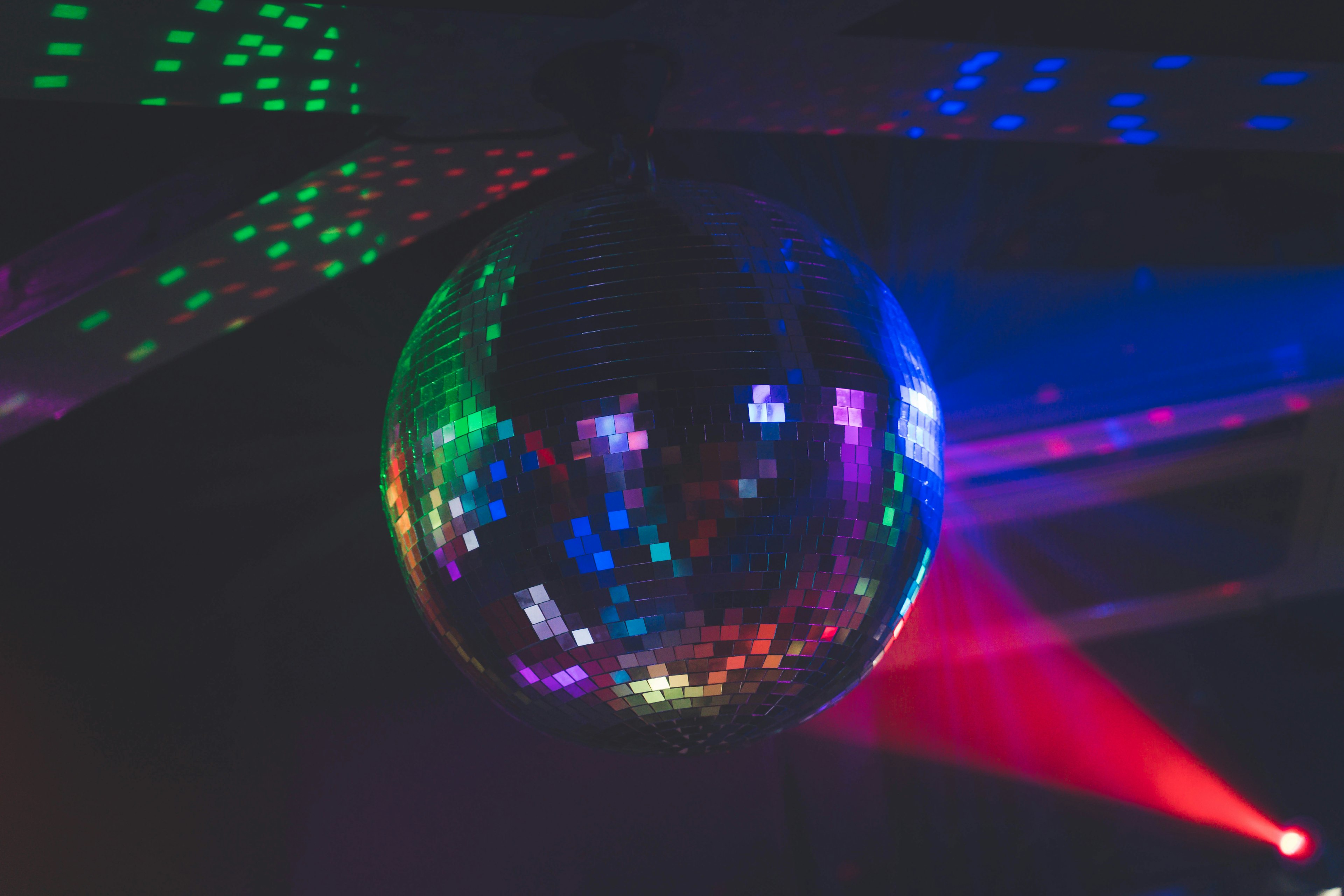 A disco ball reflecting colorful lights hanging from the ceiling