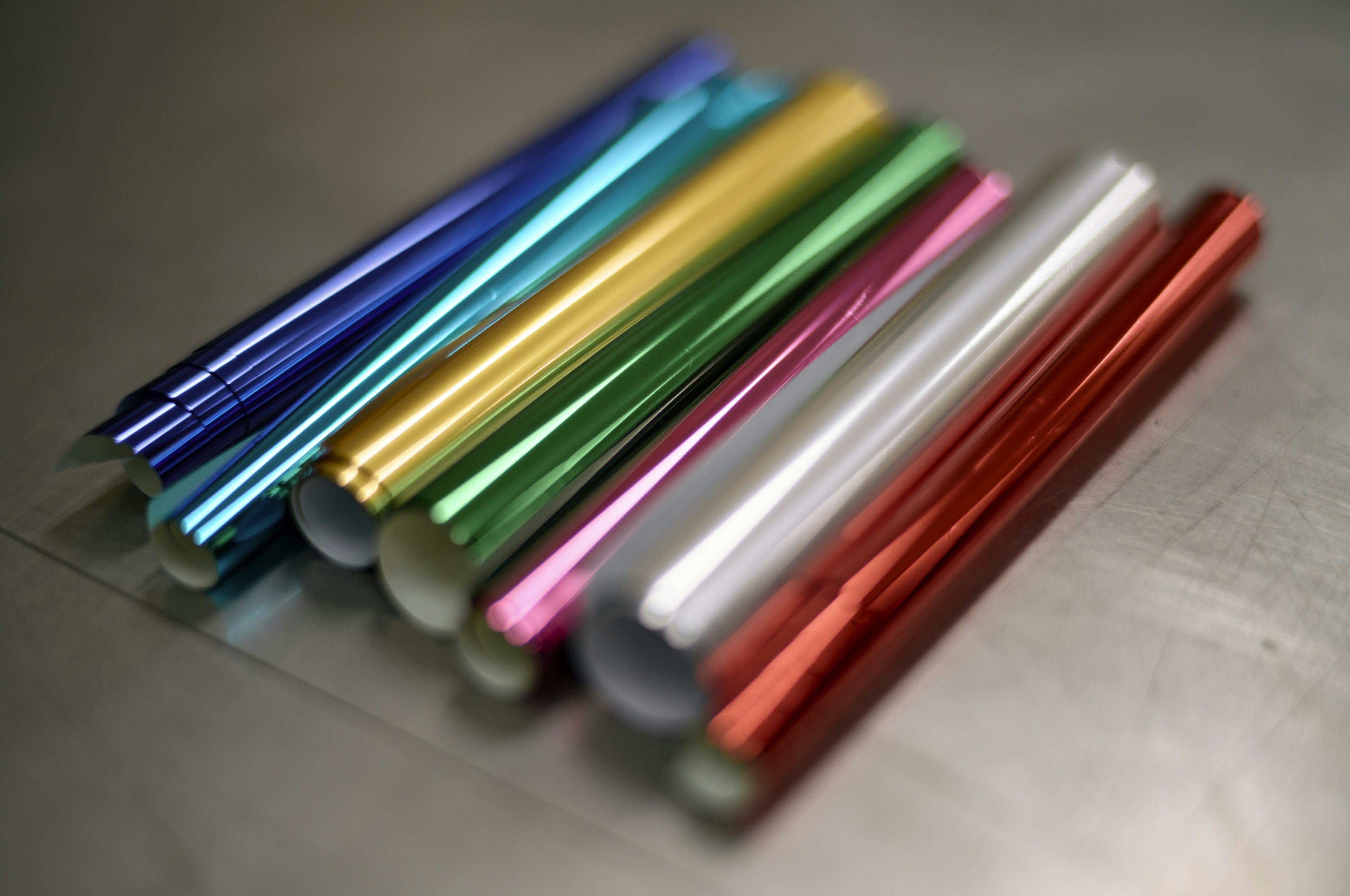 Rouleaux colorés de papier aluminium disposés sur une surface métallique