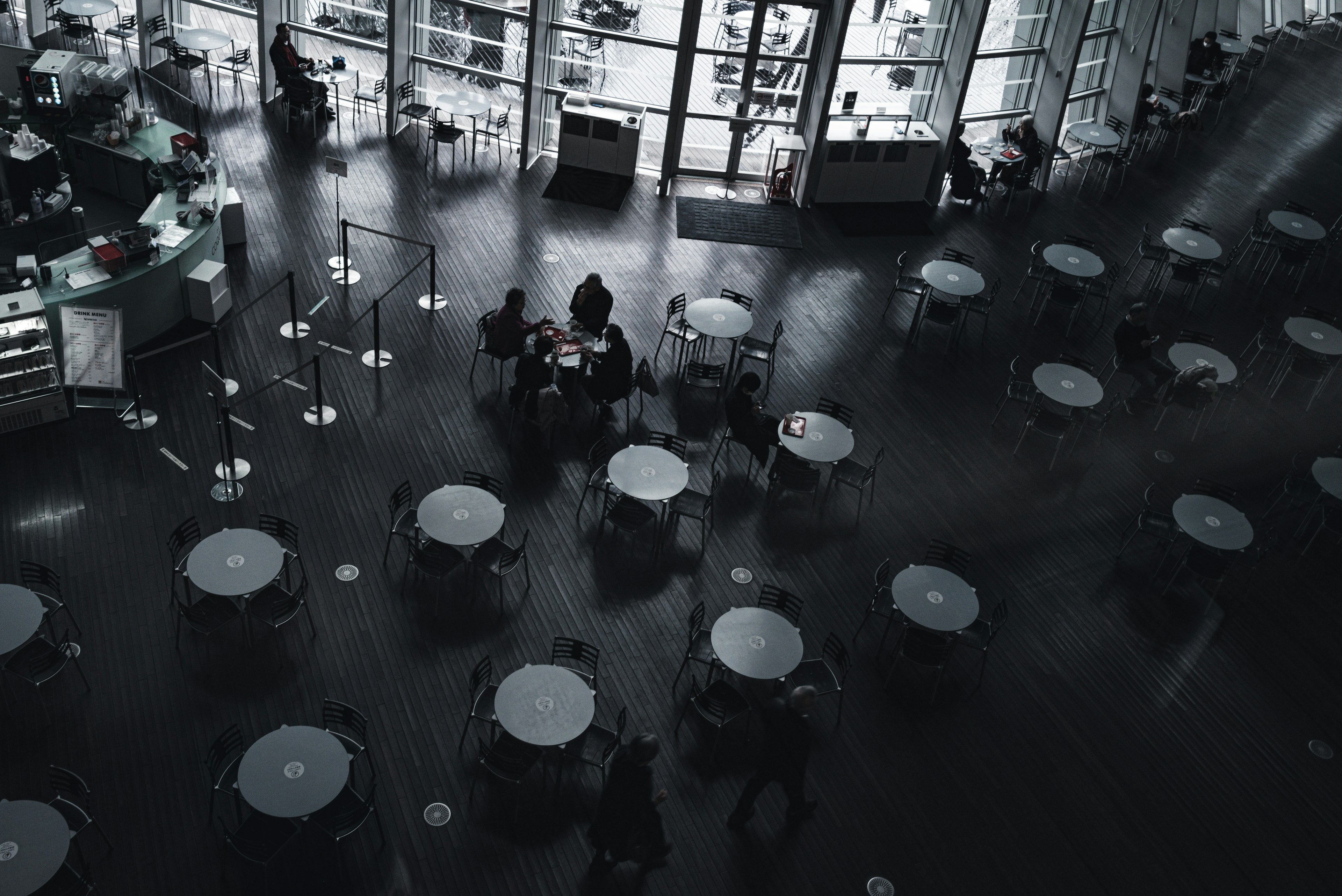 Dimly lit interior of a café with numerous tables and chairs arranged