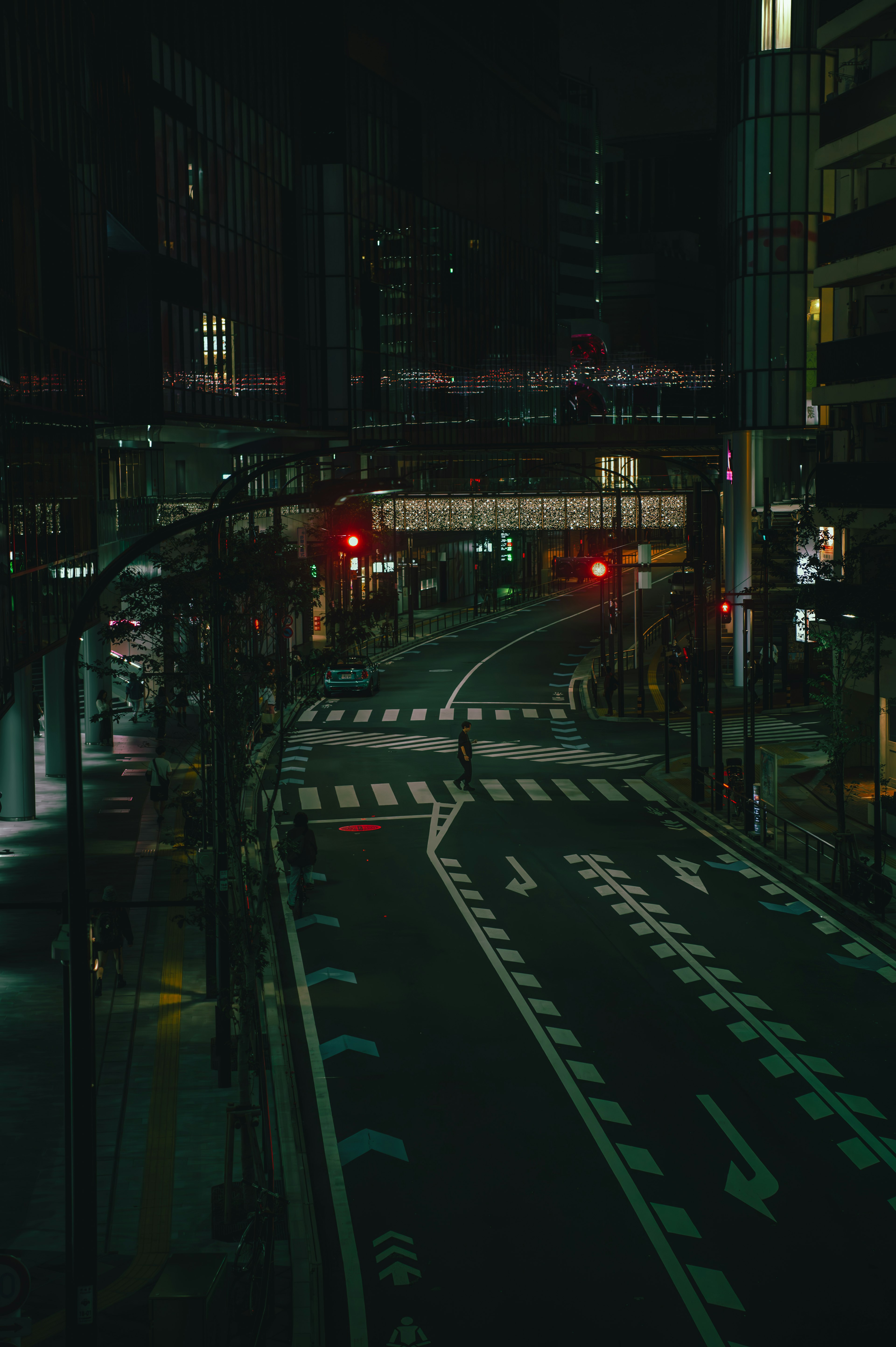 Nighttime city street with traffic signals and curved road