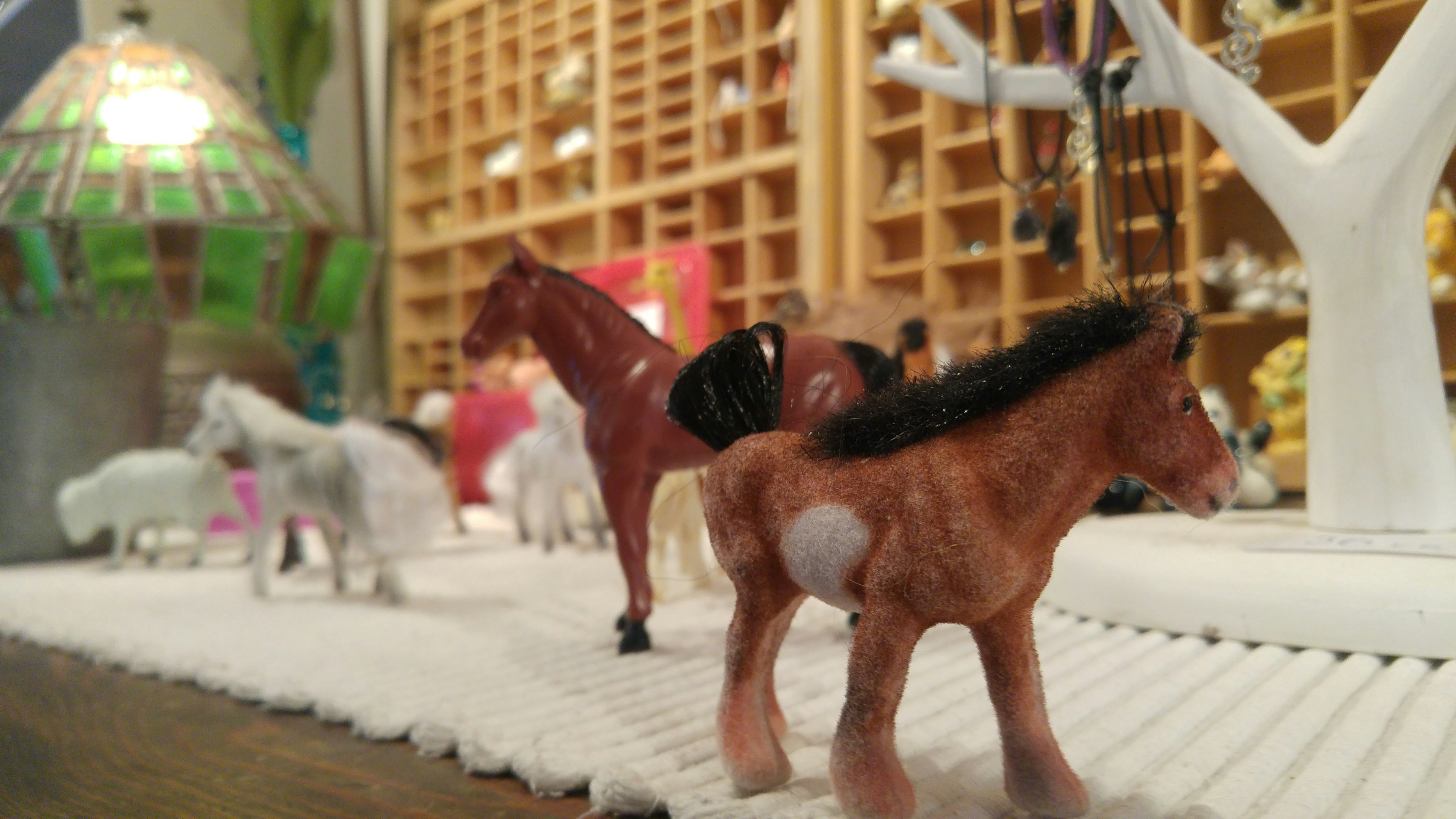 A scene featuring small horse figurines arranged on a surface