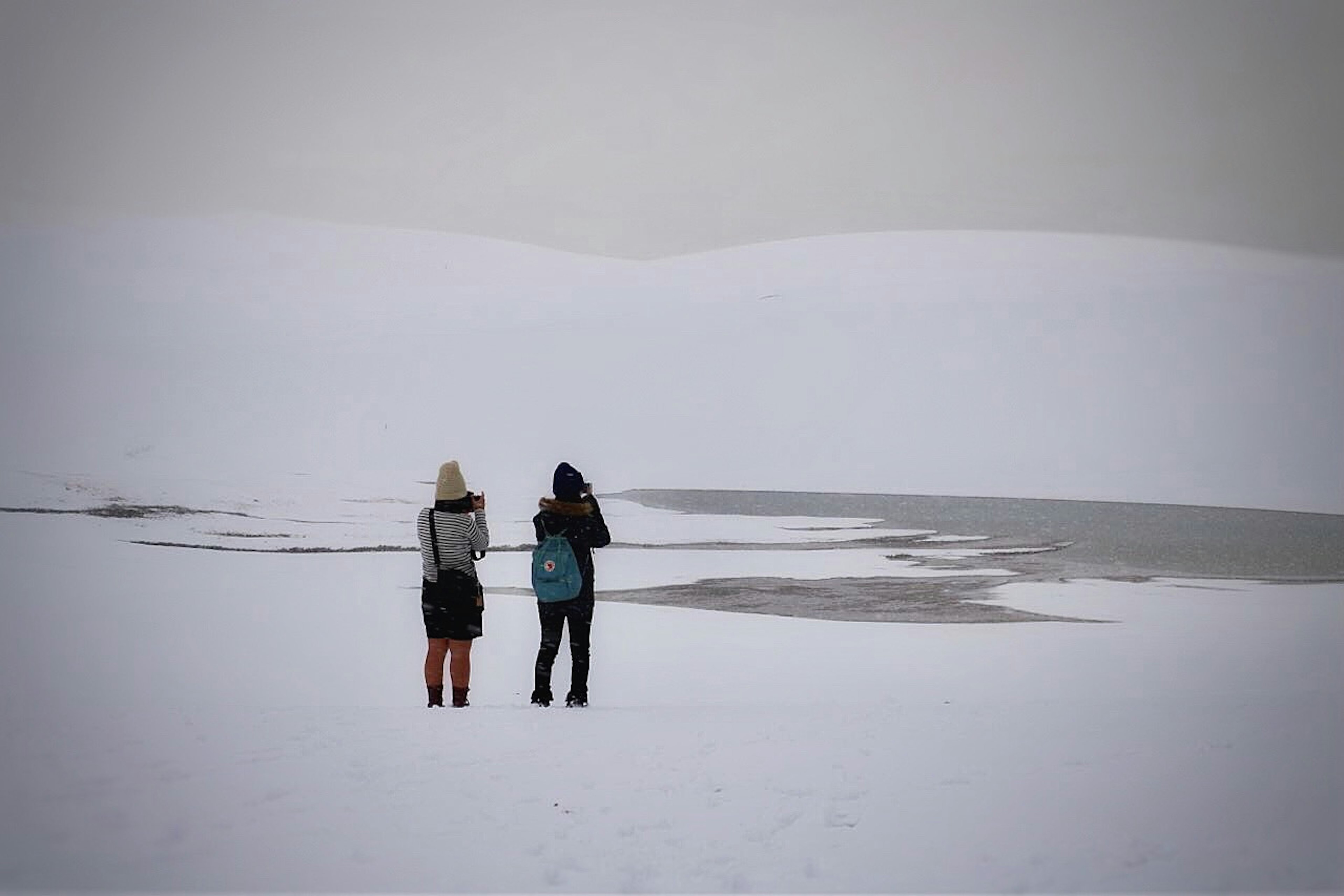 Due donne in piedi di fronte a un paesaggio innevato