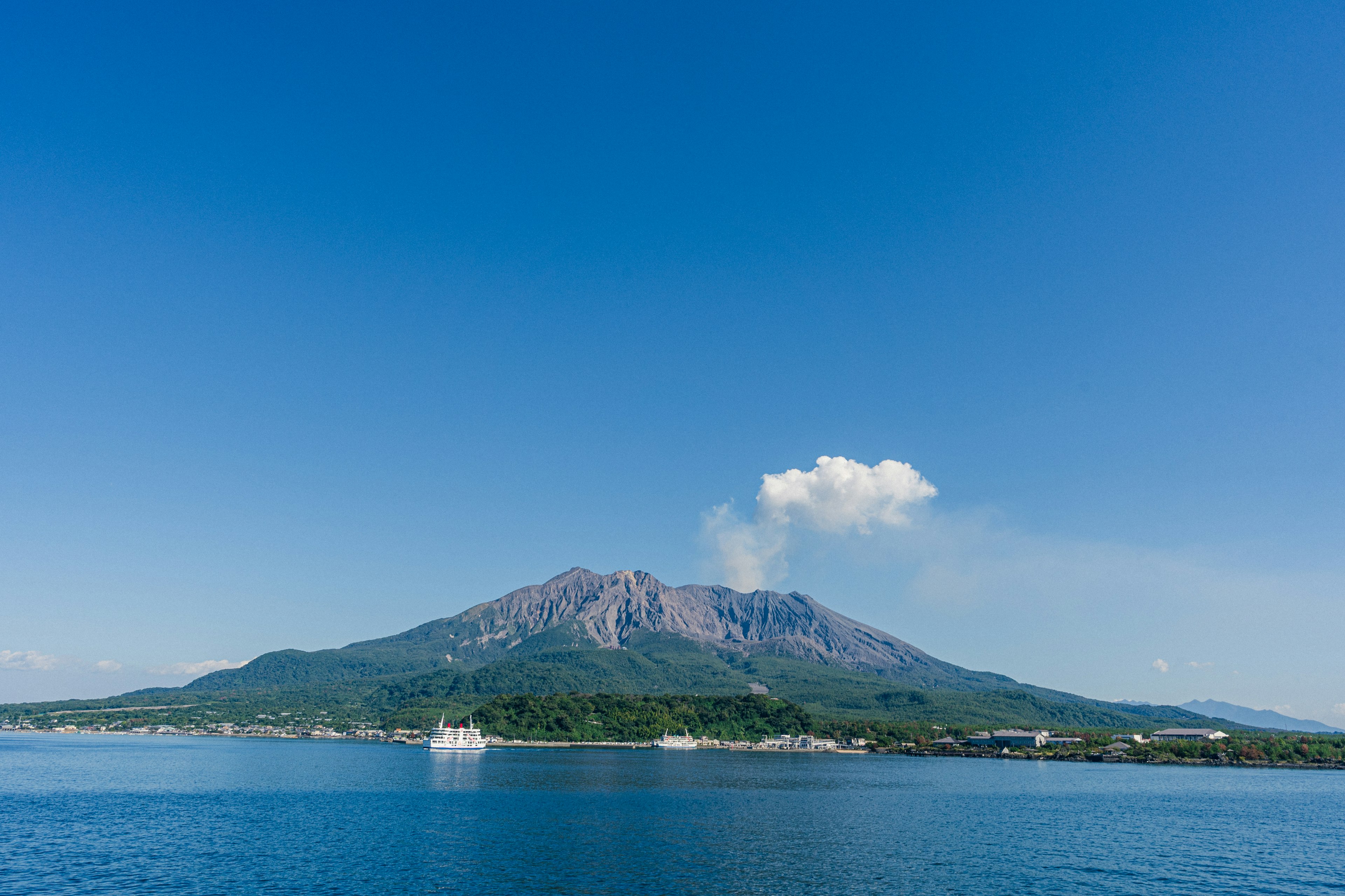 青い空と水面に映る活火山の風景