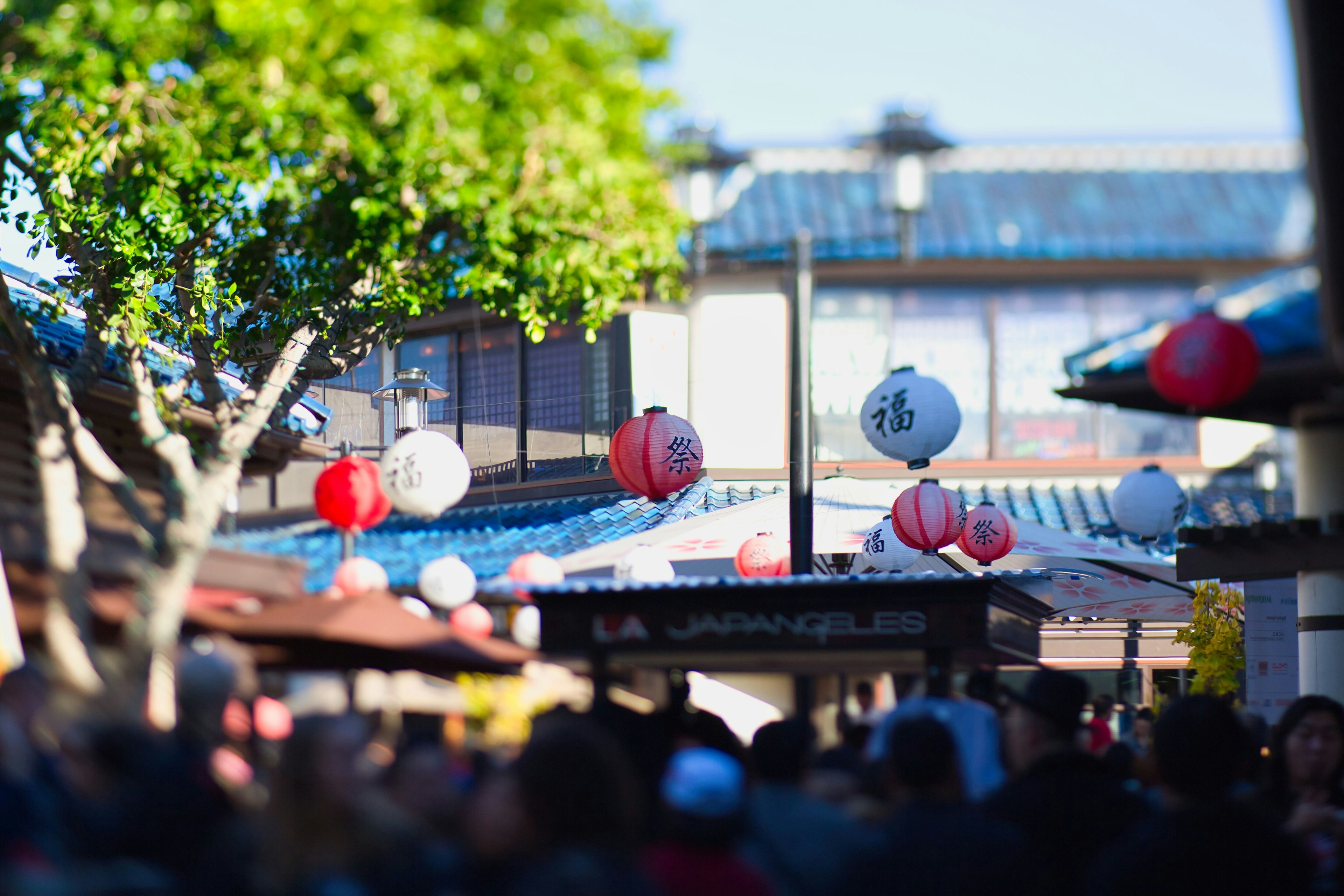 Bustling street market with red and white lanterns hanging above