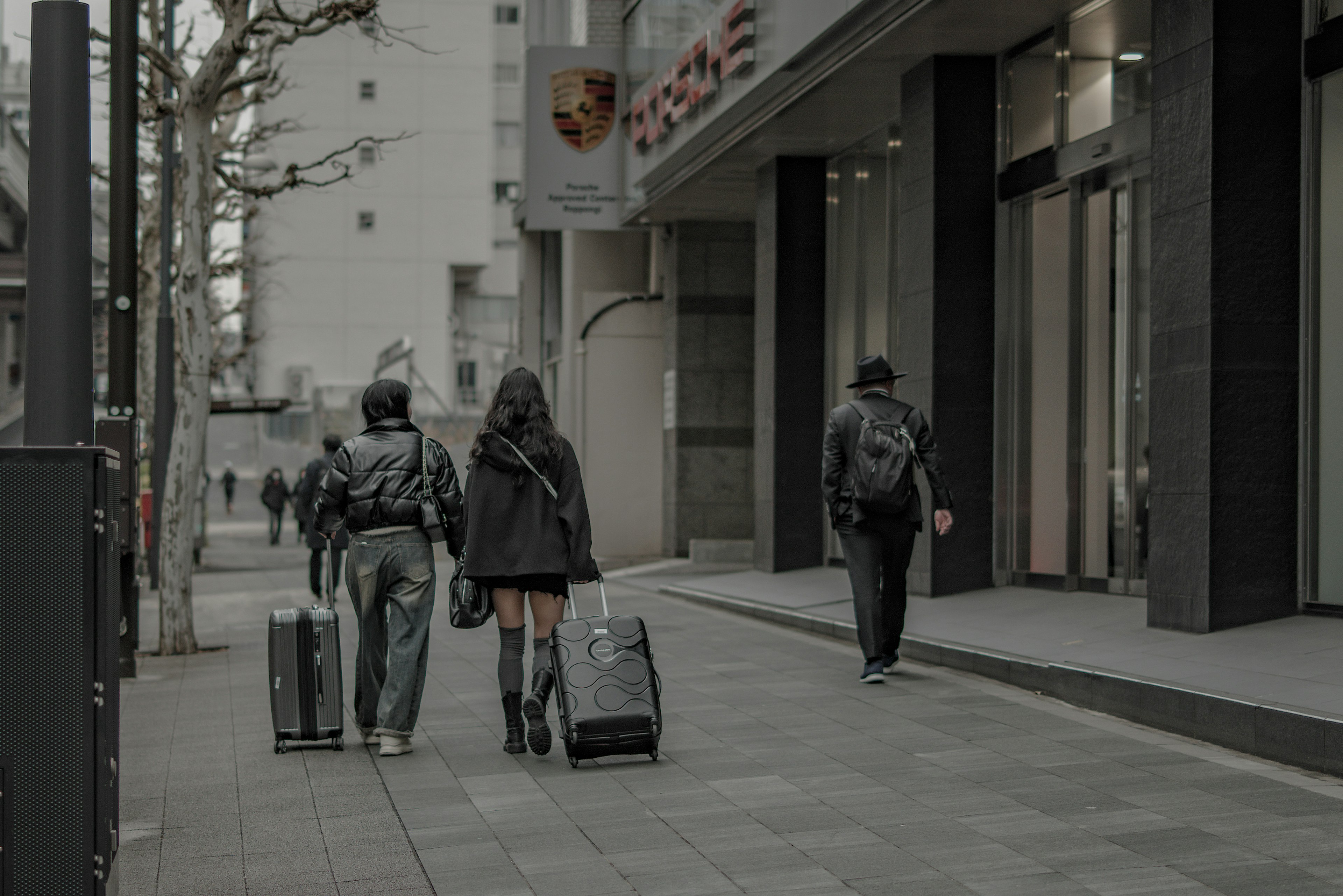 街を歩く人々とスーツケースの風景