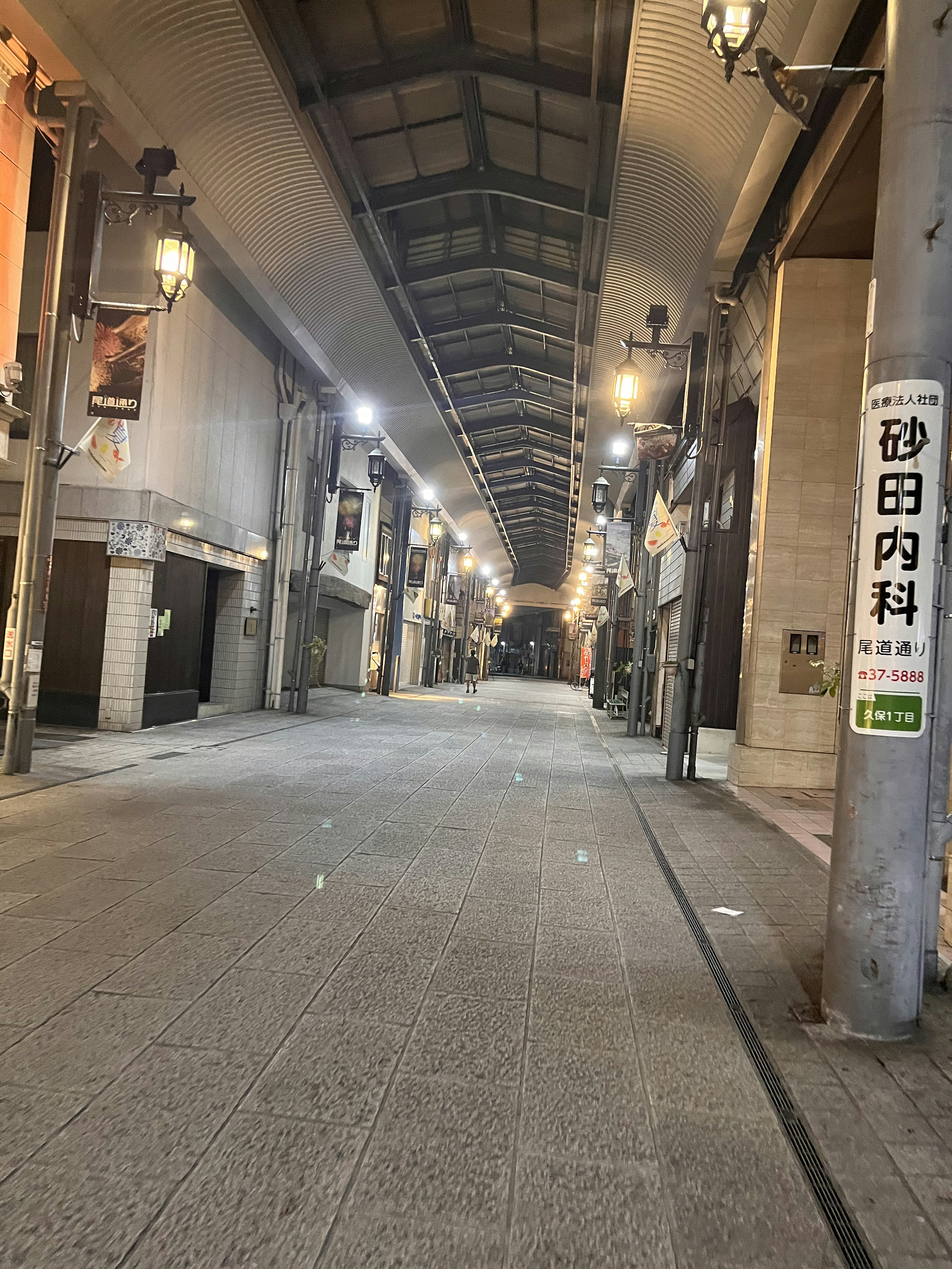 静かな夜の商店街の通り ほのかな明かりが灯る