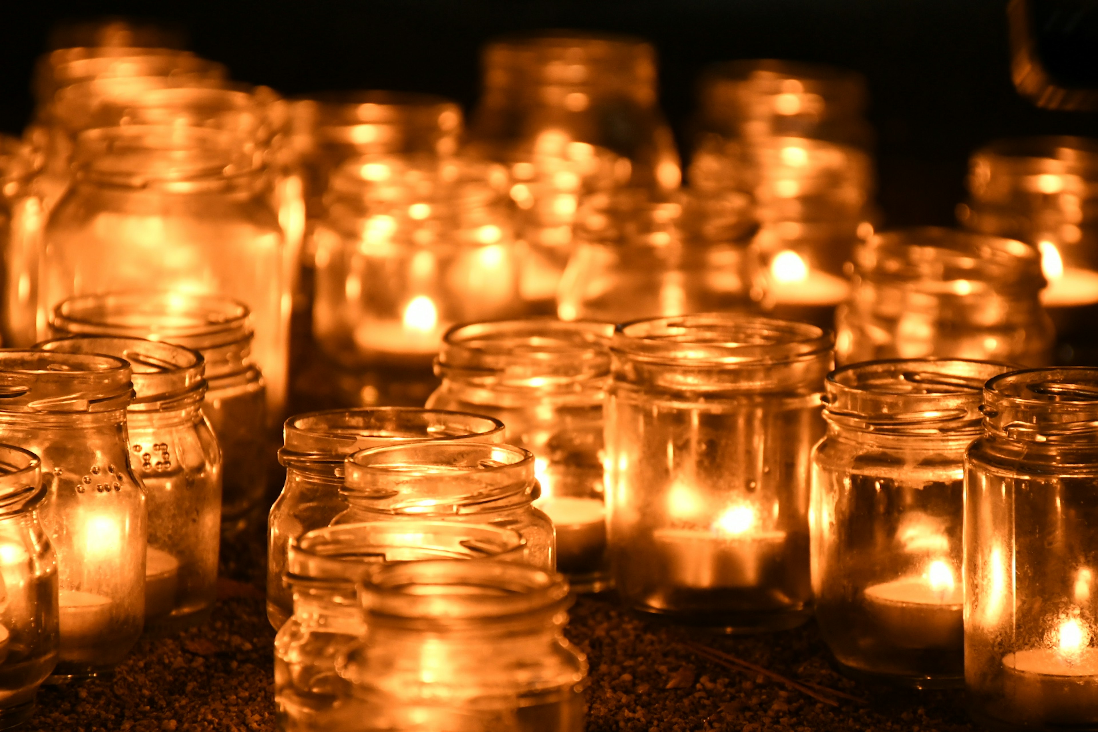 A collection of glass jars filled with glowing candles creating a warm ambiance