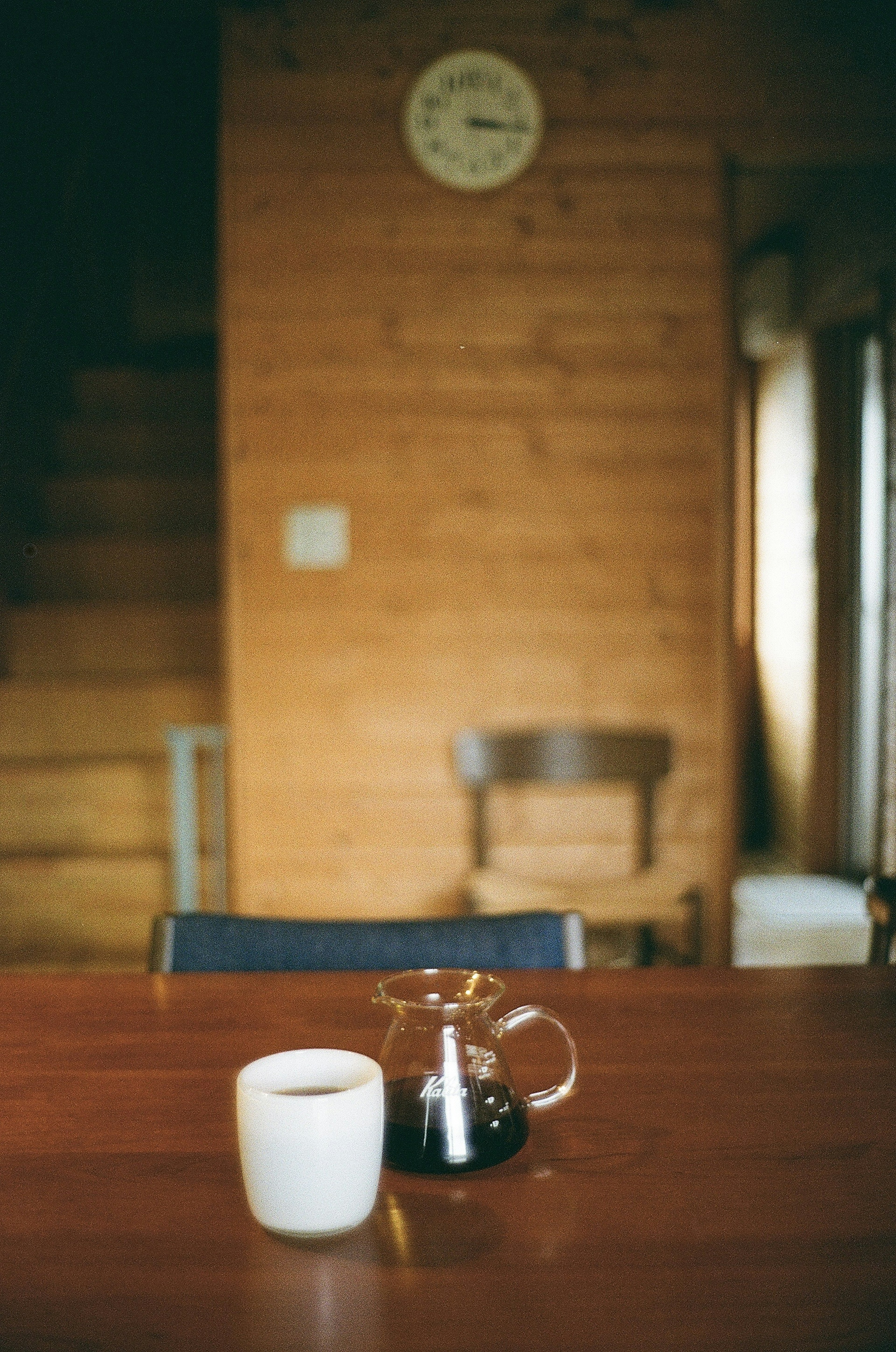 Ein gemütliches Interieur mit einem Holztisch, einer Kaffeetasse und einer Kaffeekanne