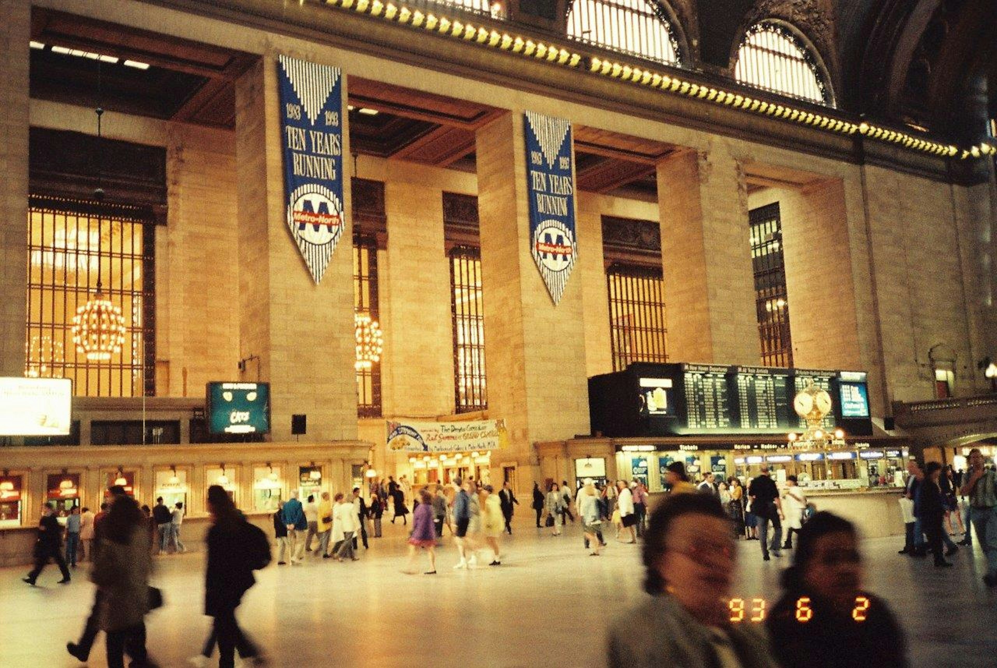 Interno della Grand Central Station affollato di persone grandi finestre e bandiere decorative