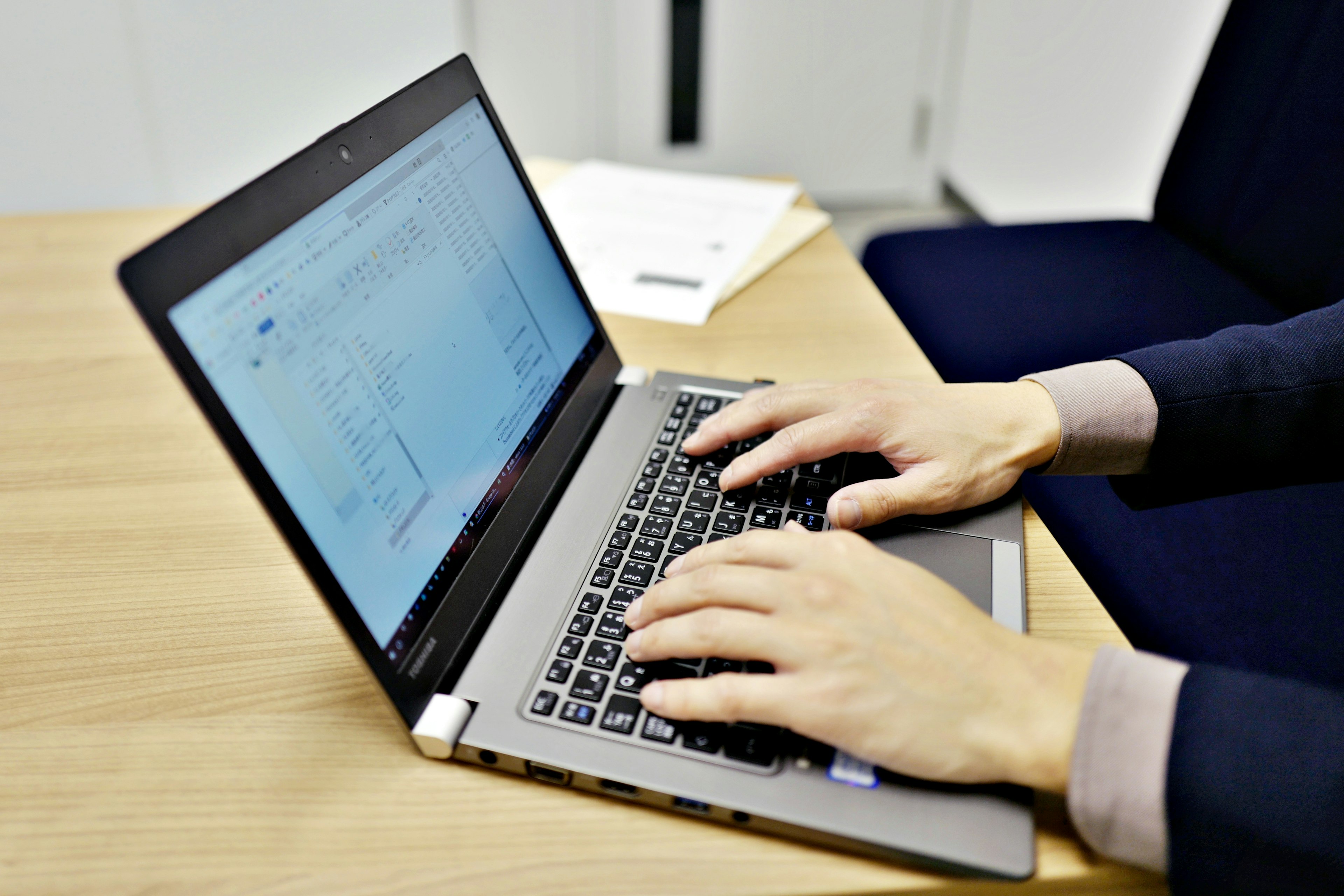 Close-up of hands typing on a laptop keyboard