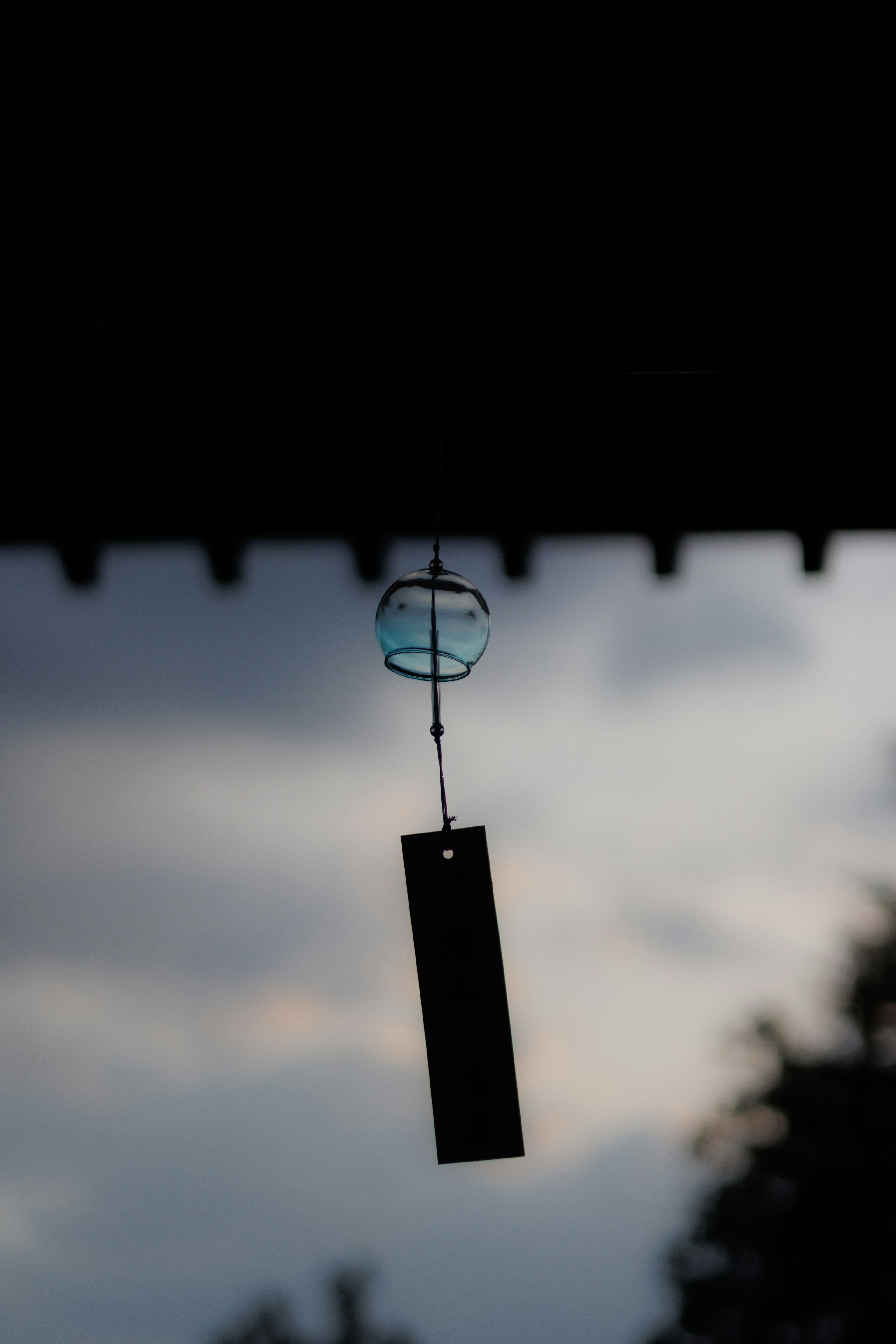 Wind chime silhouetted against a twilight sky