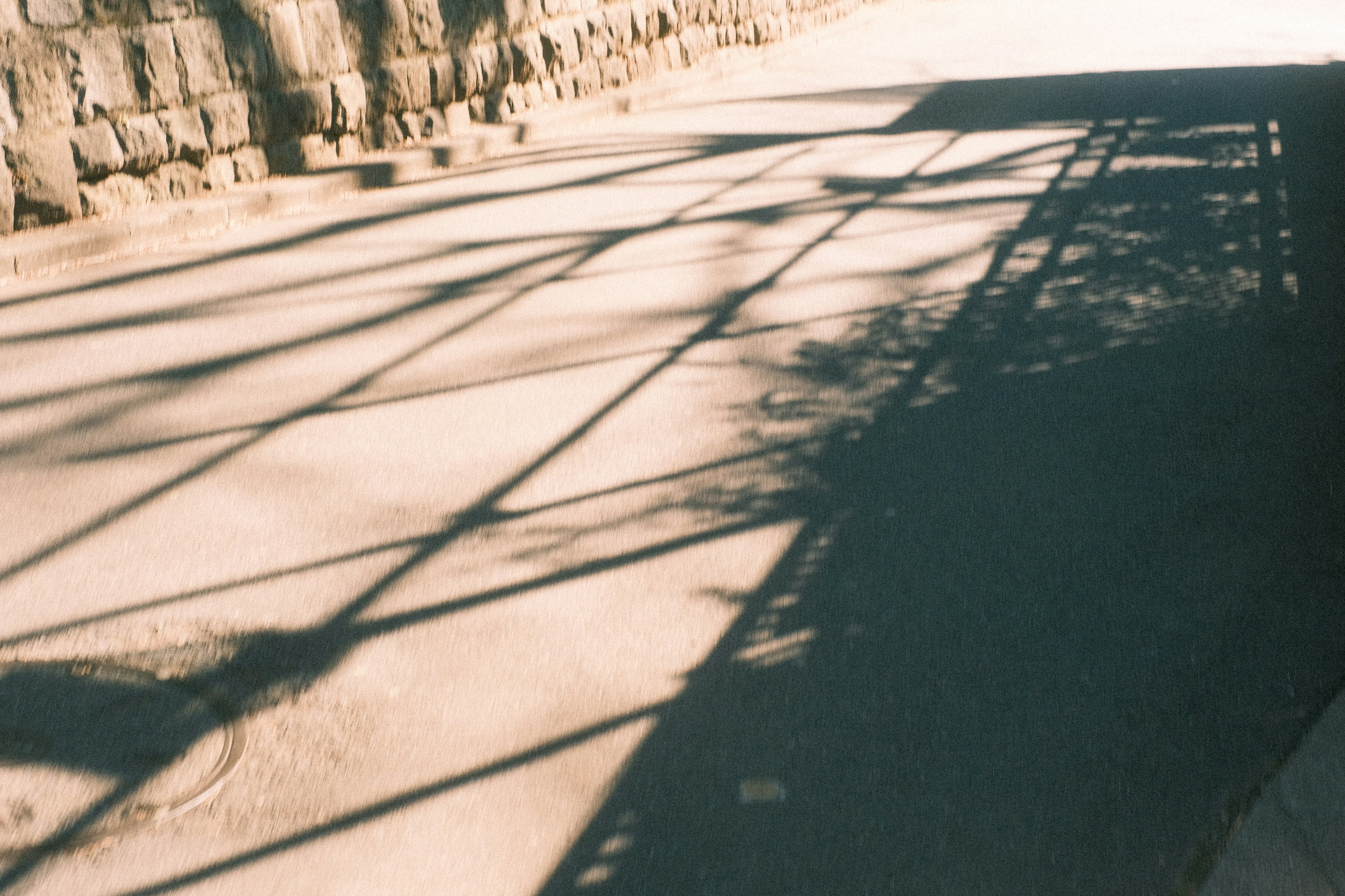 Camino tranquilo con pared de piedra y sombras